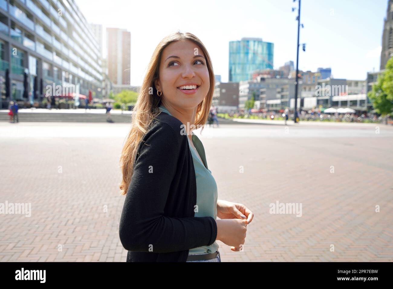 Porträt einer schönen multiethnischen Frau, die in Rotterdam mit moderner Architektur in den Niederlanden spazierengeht Stockfoto