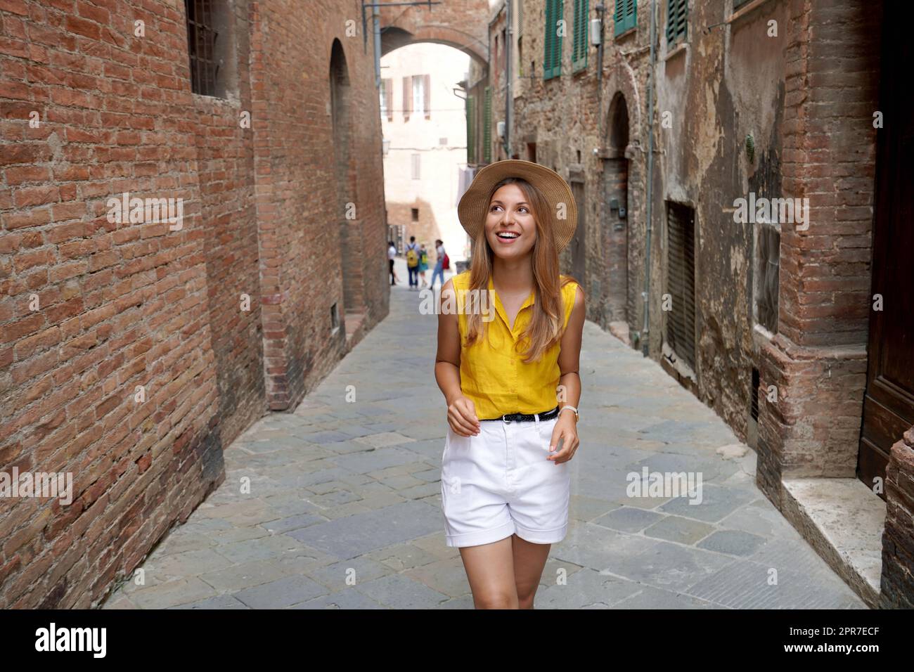 Urlaub in der Toskana. Schöne stilvolle Tourist Mädchen zu Fuß zwischen engen Gassen von Siena historische Stadt der Toskana, Italien. Stockfoto