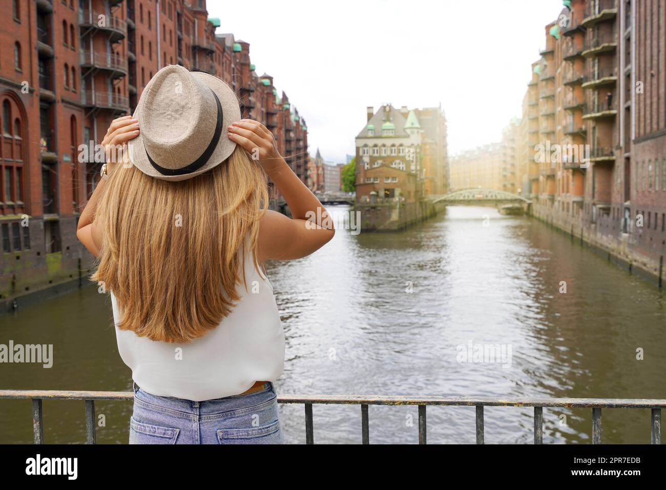 Tourismus in Deutschland. Schöne junge Frau, die Speicherstadt im Hamburger Hafen besucht. UNESCO-Weltkulturerbe. Stockfoto