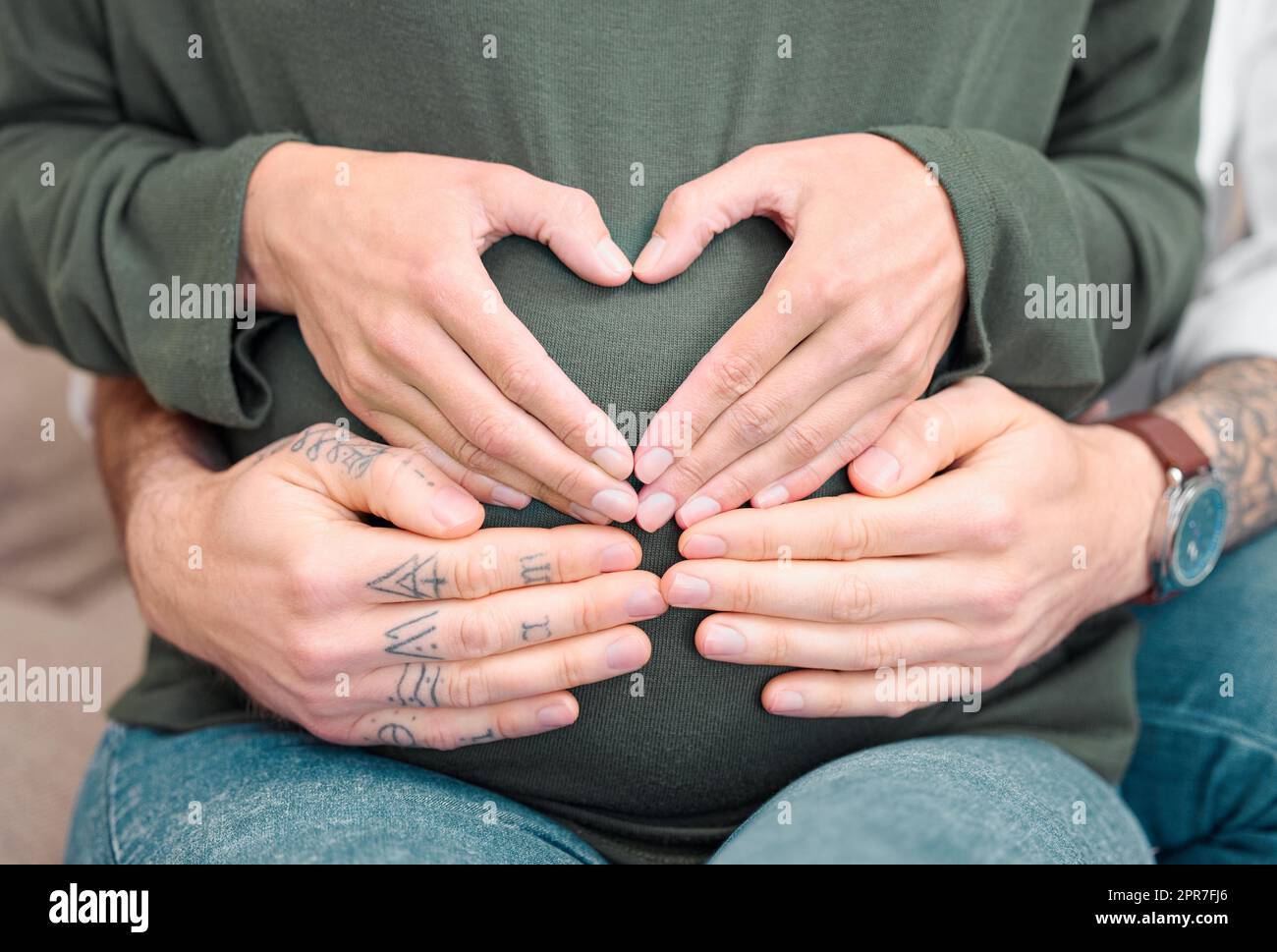 Elternschaft ist eine praktische Aufgabe. Zugeschnittene Aufnahme eines unverkennbaren Paares, das mit den Händen auf dem Bauch der werdenden Mutter sitzt. Stockfoto