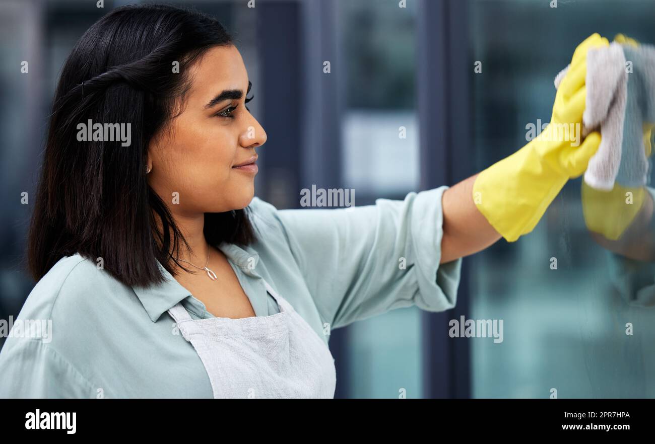 Saubere Fenster für eine bessere Aussicht. Nahaufnahme einer Frau, die Handschuhe trägt und beim Reinigen der Fenster ein Tuch verwendet. Stockfoto