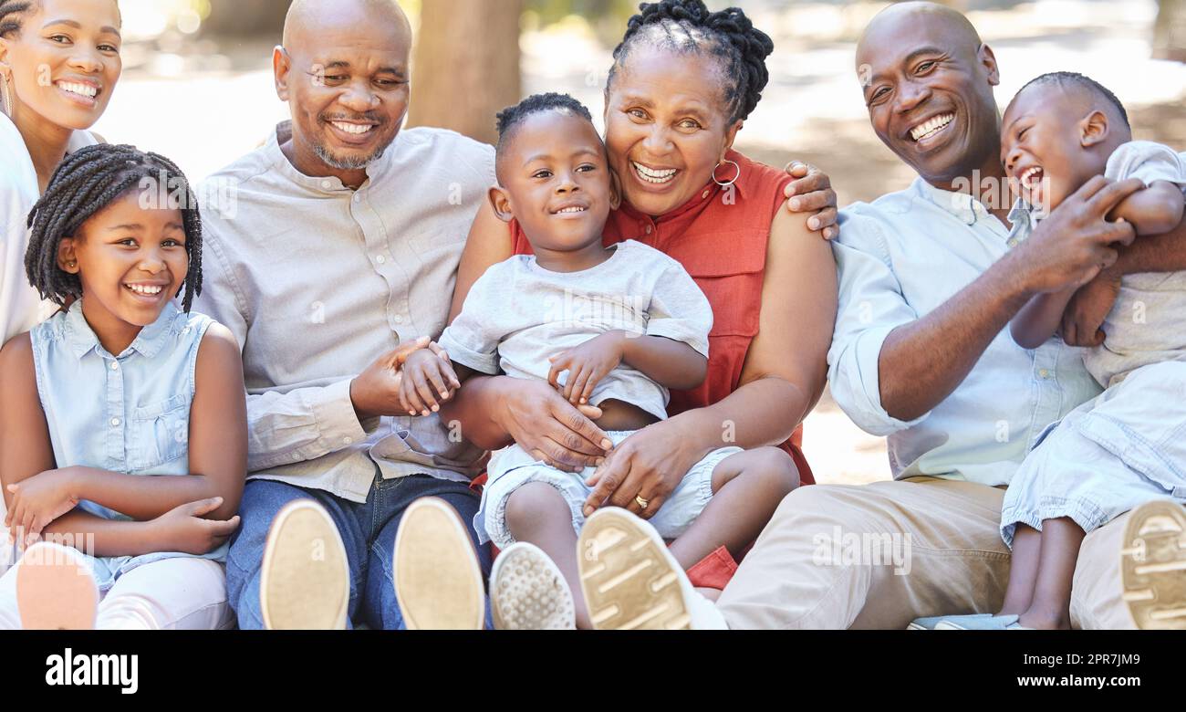 Portrait glückliche afroamerikanische Familie mit sieben Personen, die im Sommer Zeit im Park verbringen. Großeltern, Eltern und Kinder, die sich draußen anfreunden. Ein Ausflug mit den Kindern Stockfoto