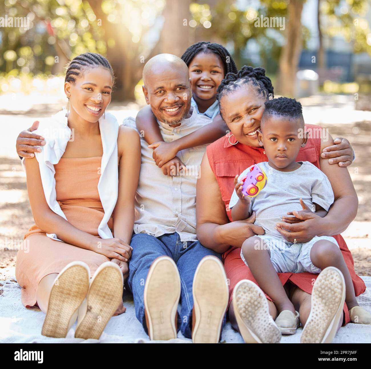 Portrait glückliche afroamerikanische Familie mit fünf Personen, die im Sommer eine schöne Zeit zusammen im Park verbringen. Großeltern, Mutter und Kinder, die sich draußen anfreunden. Ein Ausflug mit den Kindern Stockfoto