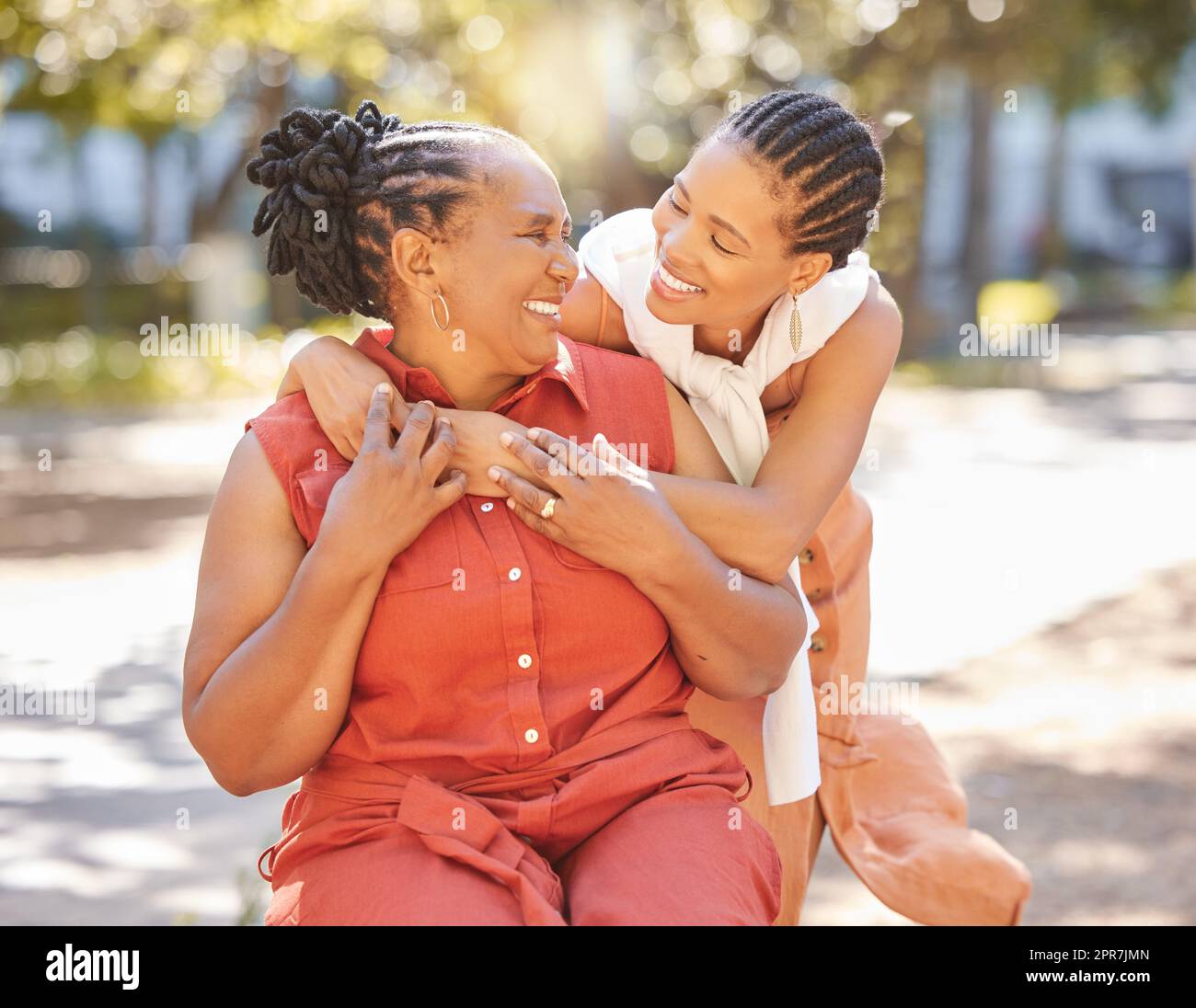 Glückliche, reife Frau und ihre Erwachsene Tochter verbringen im Sommer Zeit im Park. Schöne Frau und ihre Mutter, die sich draußen anfreunden. Eine ältere Dame und ihr erwachsenes Kind lächelnd Stockfoto