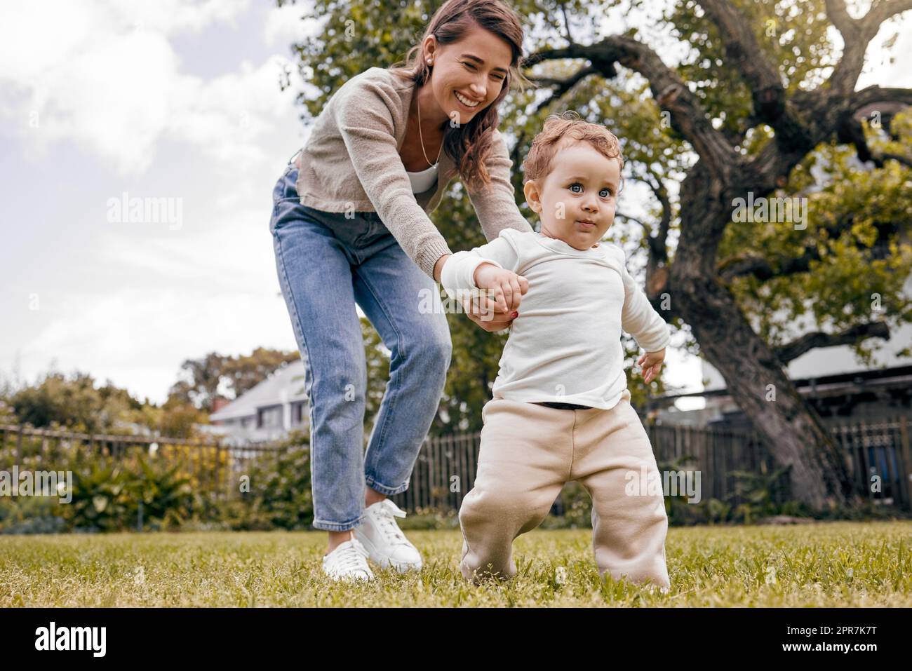 Seine kleinen Füße rannten mit ihm fort. Eine Mutter und ein Sohn spielten draußen. Stockfoto