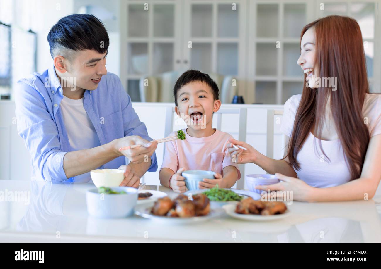 Glückliche asiatische Familie, die zu Hause zu Abend gegessen hat Stockfoto