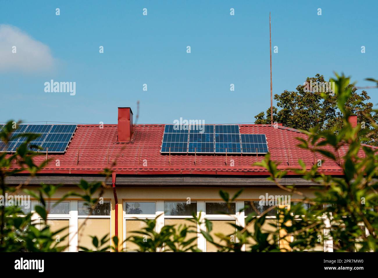 Photovoltaik- oder Solarpaneele auf einem roten Dach Stockfoto
