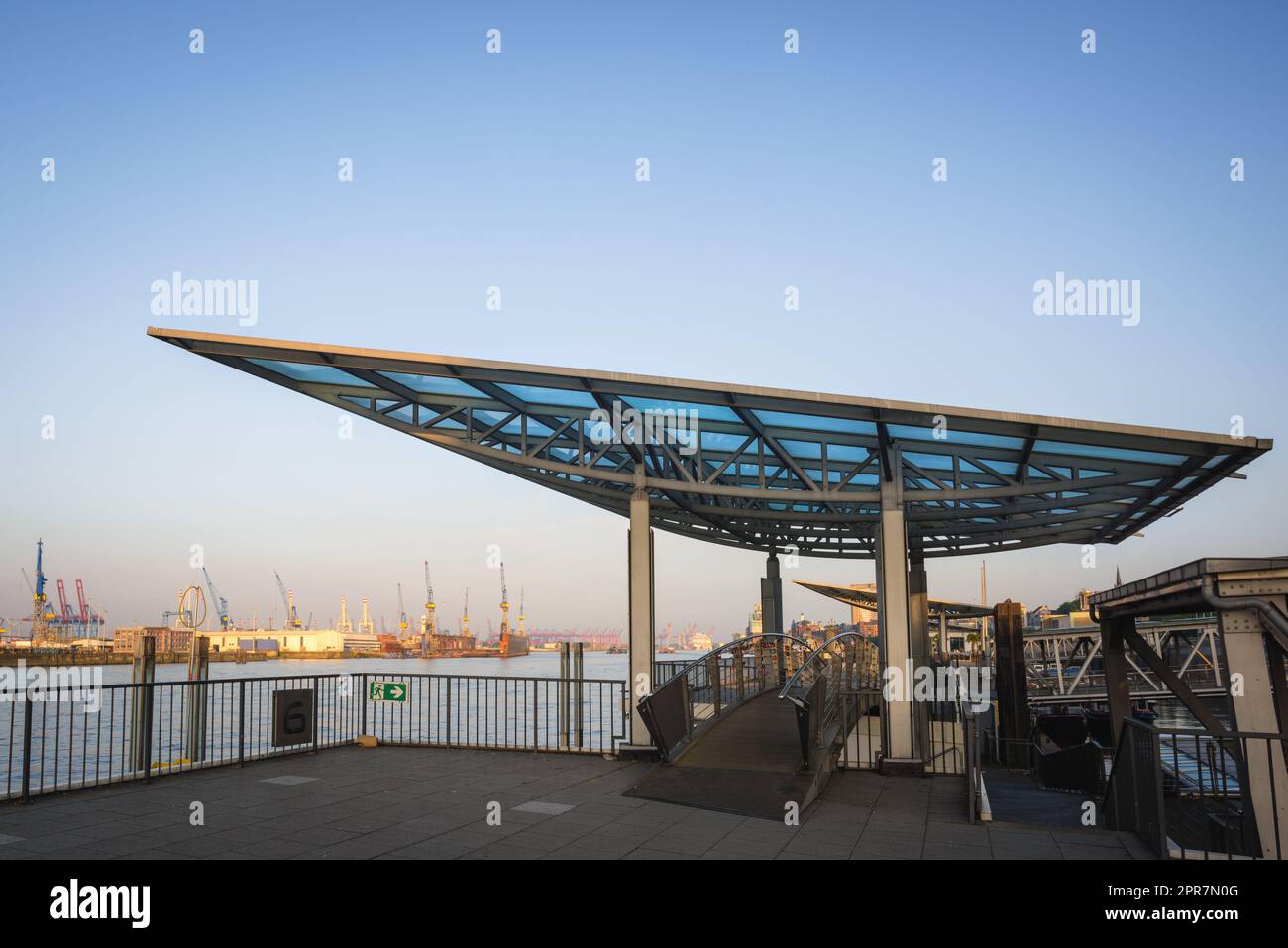 Der berühmte Anblick von Hamburg, der Landungsbrücken, an der elbe mit kleinen Booten. Leute, die durch einen Gang zum Pier laufen. Stockfoto