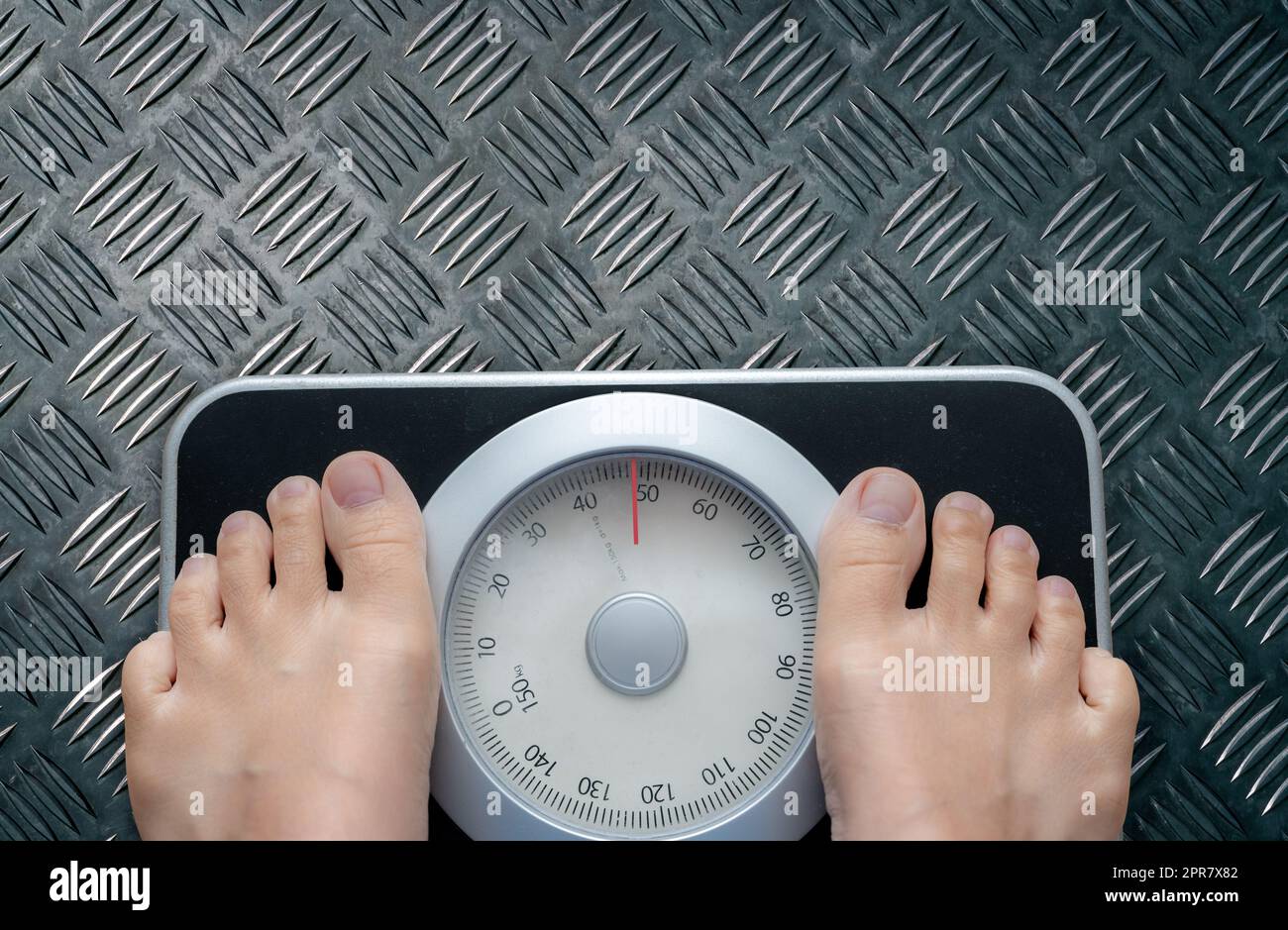 Draufsicht der Füße auf der Waage. Frauen wiegen nach Diätkontrolle auf einer Gewichtsbilanzskala. Gesundes Körpergewicht. Gewicht und Fettabbau. Gewichtsmessgerät. Body-Mass-Index oder BMI-Konzept. Stockfoto