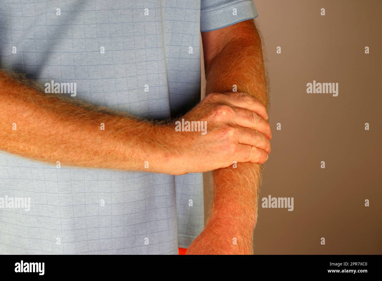Der Erwachsene Weiße massiert seinen linken Unterarm mit der rechten Hand Nahaufnahme Stockfoto