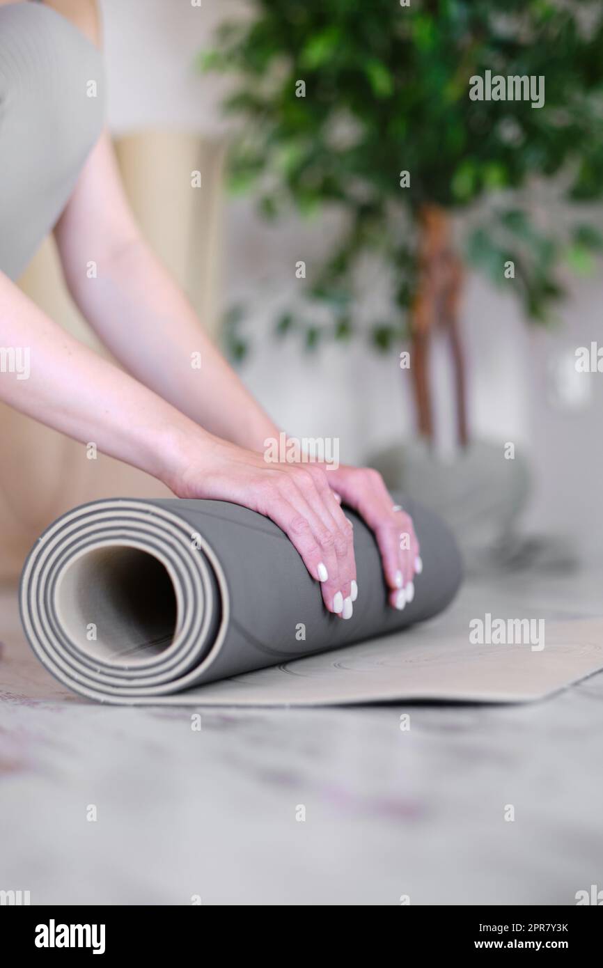 Nahaufnahme der Hände einer Frau, die eine Matte für Yoga oder Meditation vorbereitet. Stockfoto