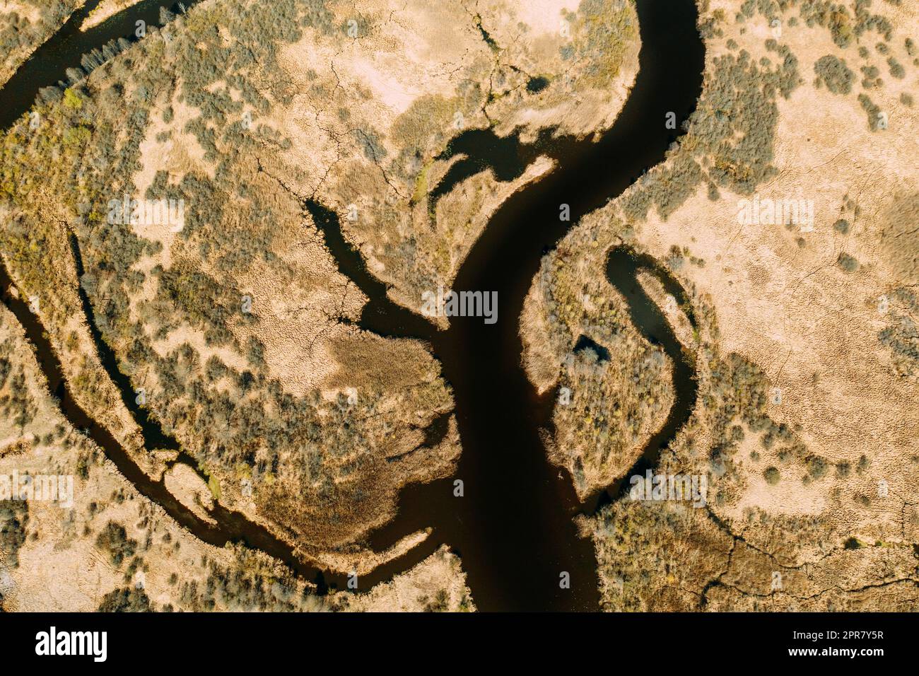 Luftaufnahme Des Geschwungenen Flusses In Der Frühlingslandschaft. Flussbiegungen und trockene Graslandschaft. Blick Von Oben Auf Die Wunderschöne Europäische Natur Von High Attitude. Drohnenansicht. Vogelperspektive Stockfoto
