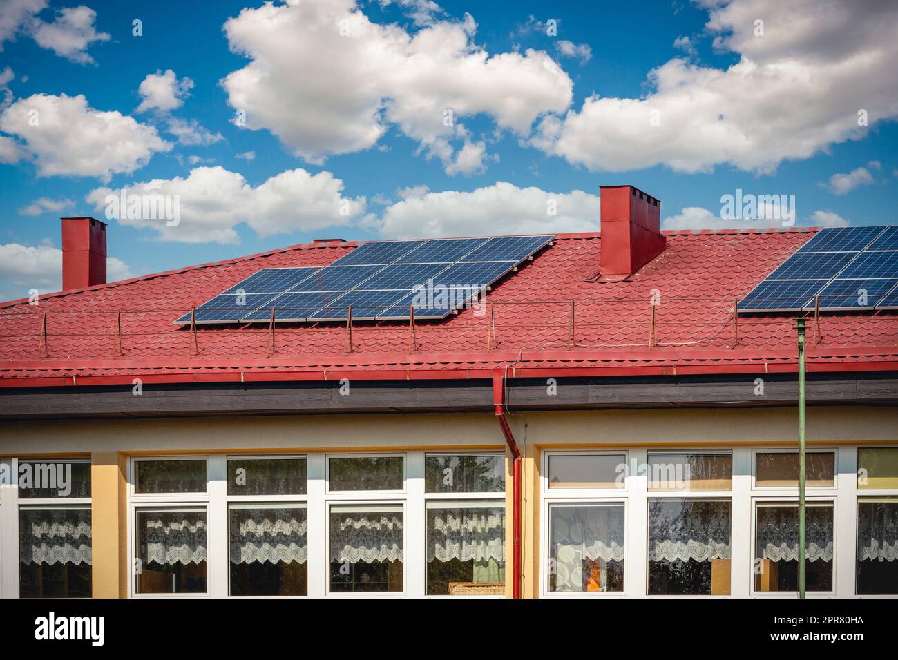 Solarzellenpaneele verwenden erneuerbare Sonnenenergie zur Stromerzeugung, die auf dem Hausdach platziert wird Stockfoto