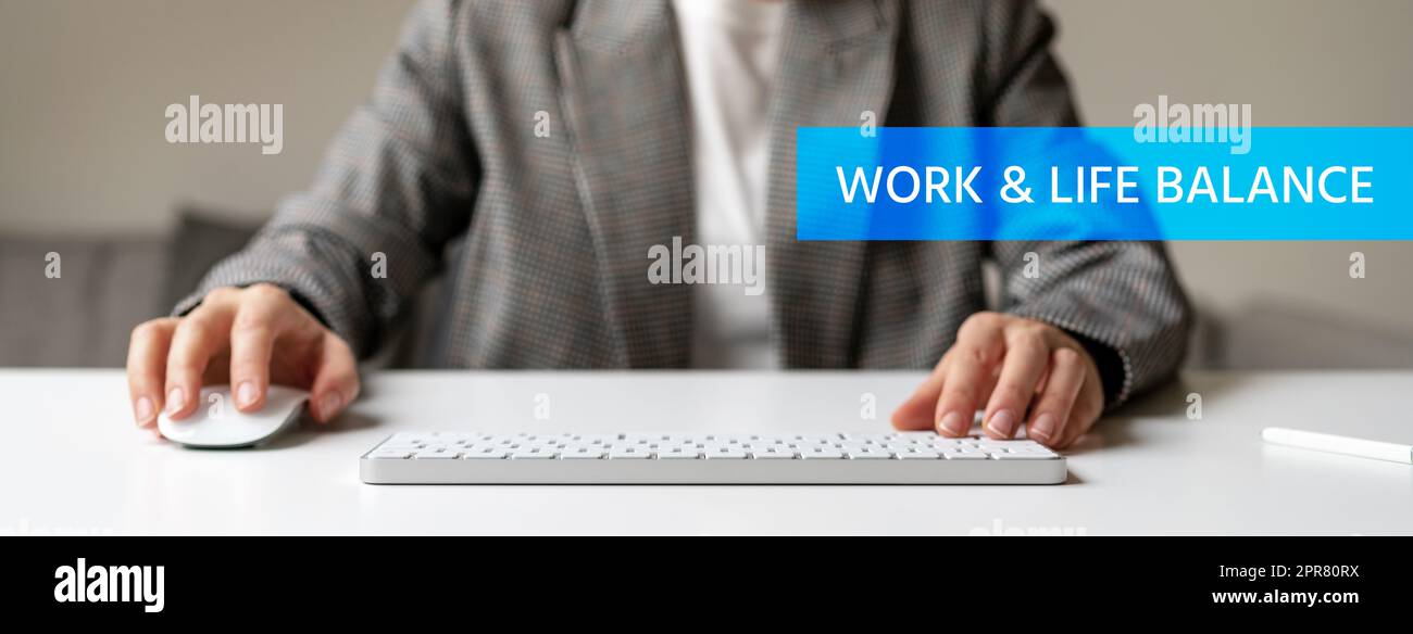 Text Work and Life Balance und Person, die am Schreibtisch im Büro im Hintergrund arbeitet. Stockfoto