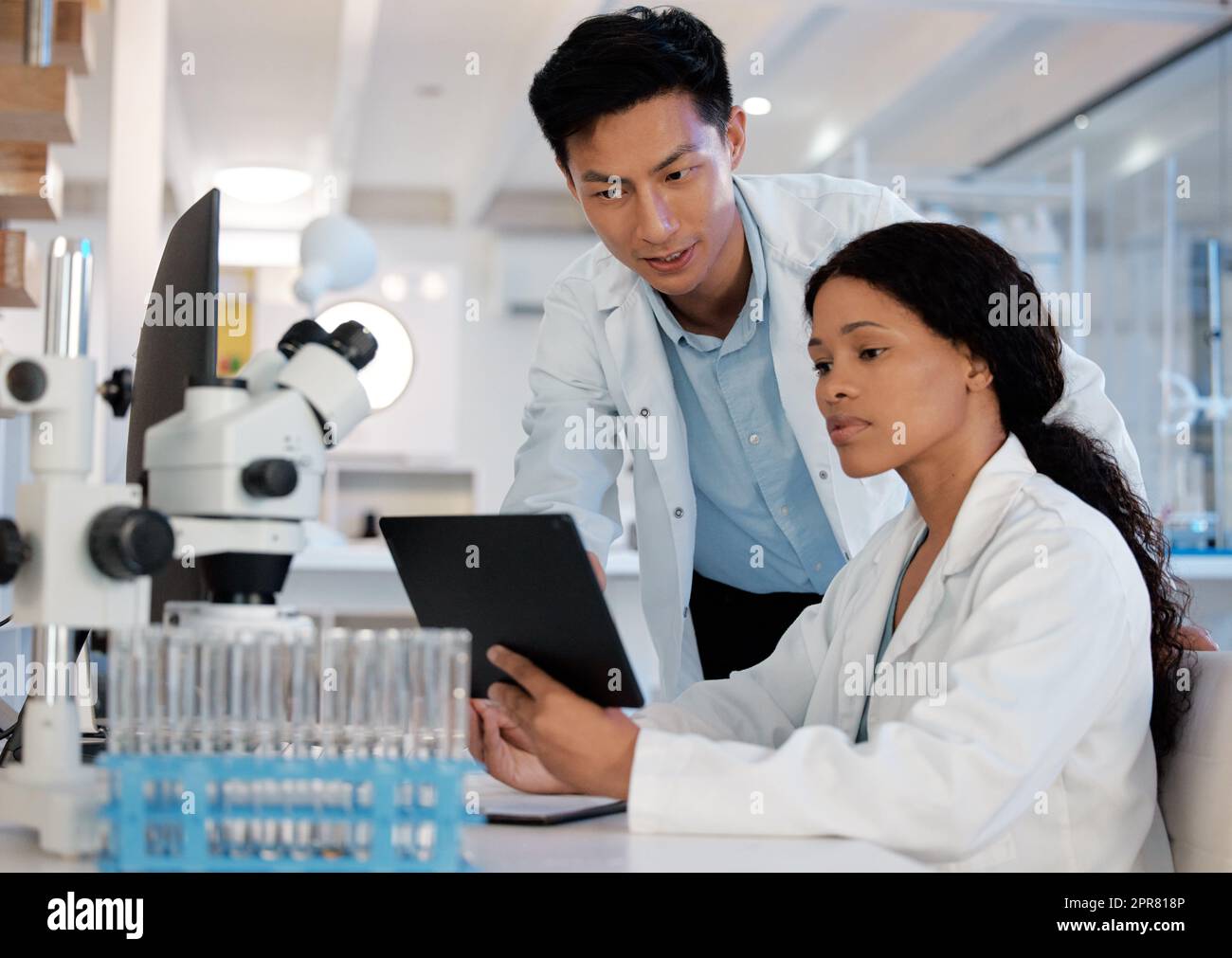 Verdoppeln Sie die Gehirnleistung. Aufnahme von zwei Labortechnikern, die mit einem digitalen Tablet zusammenarbeiten. Stockfoto