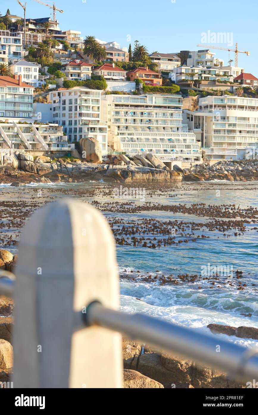Clifton, Kapstadt, Südafrika Panorama Meereslandschaft mit Wolken, blauem Himmel, schicken Hotels und Apartmenthäusern im Hintergrund. Wohnungsbau mit Blick auf die wunderschöne Halbinsel des blauen Ozeans Stockfoto