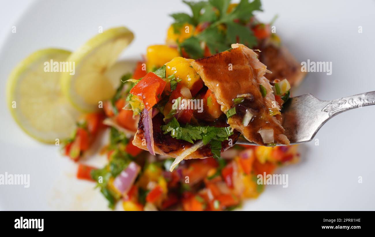 Glasiertes Lachsfilet mit Mango-Salsa, Kräutern und Zitrone Stockfoto