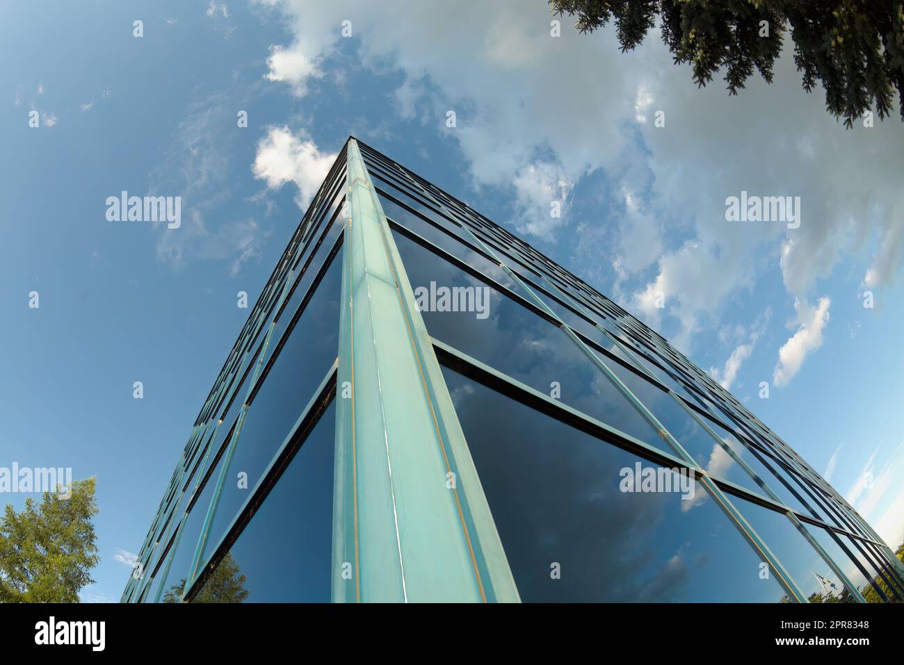 Weitwinkelfenster im Bürogebäude Wolken im Himmel reflektieren die Perspektive des Business Towers des Unternehmens Stockfoto