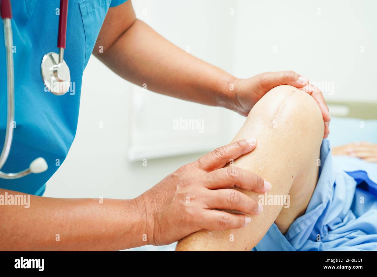 Arzt untersucht asiatische ältere Frau Patienten mit Narbe Knieersatz-Operation im Krankenhaus. Stockfoto
