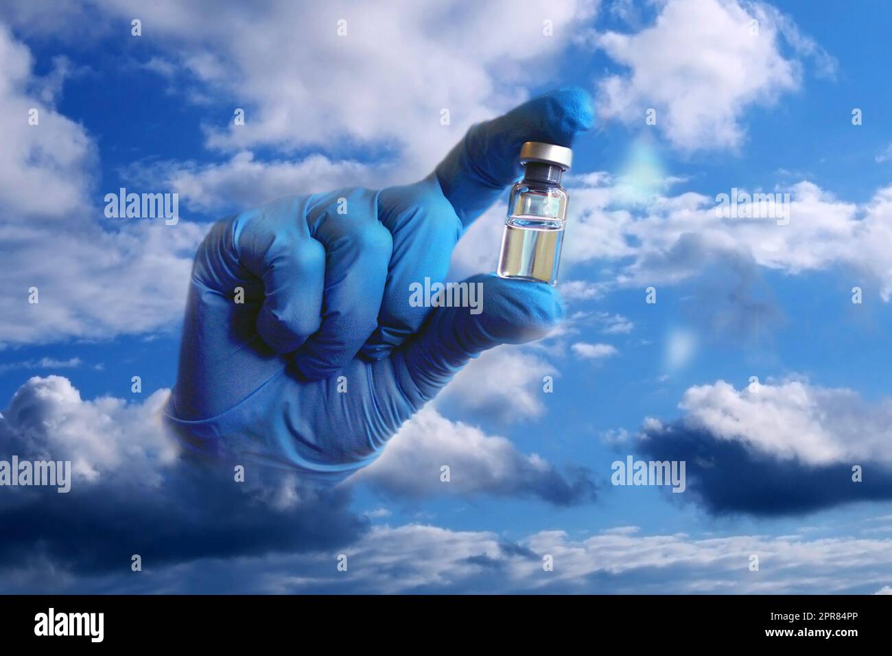 Eine Hand in einem blauen medizinischen Handschuh ragt aus den Wolken und hält ein Fläschchen Impfstoff. Collage. Stockfoto