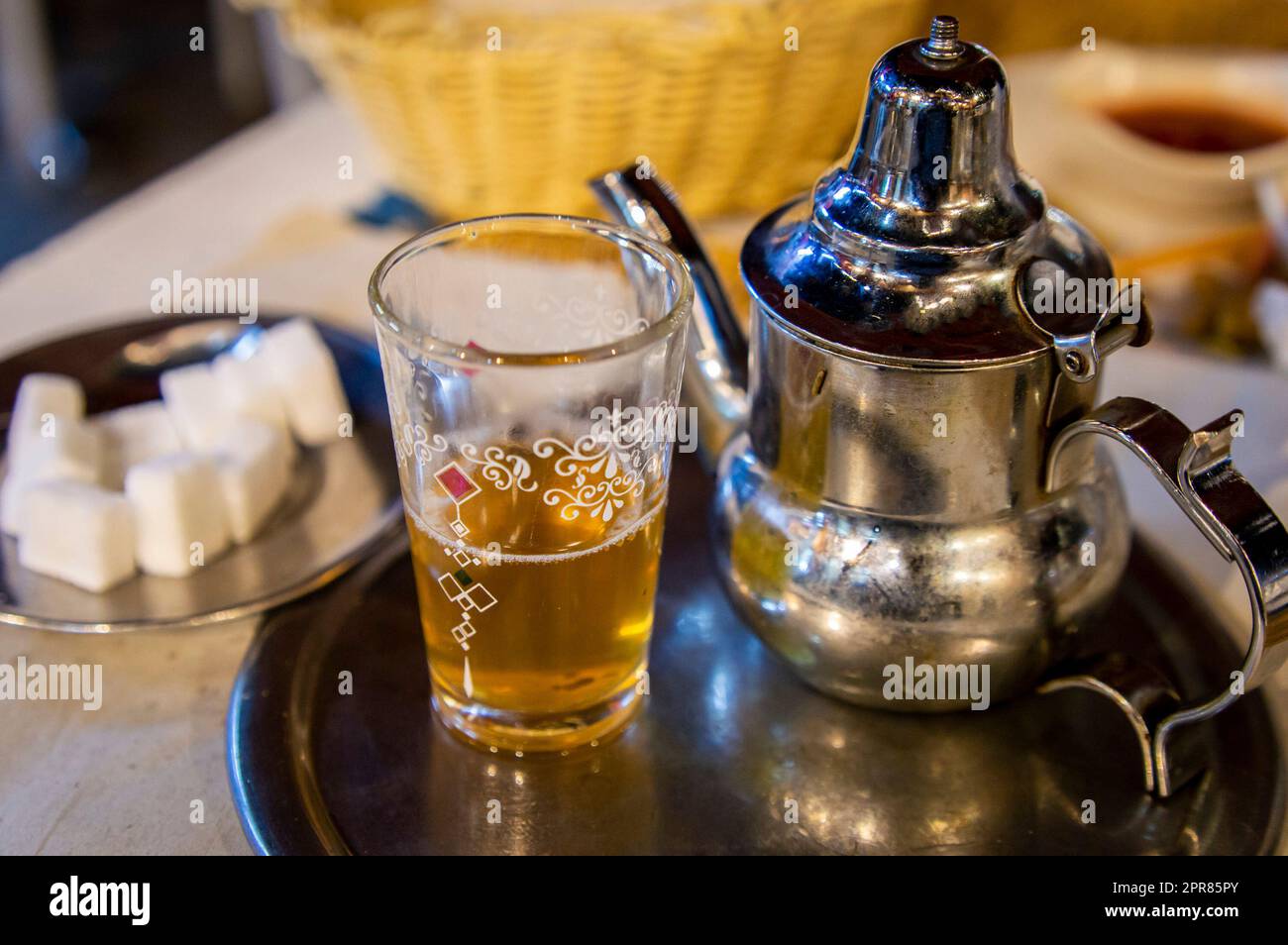 Traditioneller marokkanischer Pfefferminztee auf dem Esstisch mit Zucker zur Seite. Stockfoto