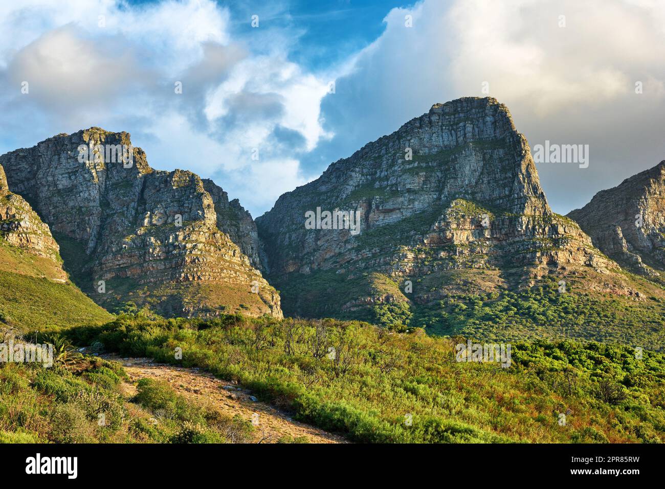 Landschaft eines Berges in Kapstadt, Südafrika am Tag. Felsiger Berggipfel mit Grün vor bewölktem Himmel. Unterhalb der beliebten Touristenattraktion und Abenteuerwanderweg in der Nähe des Tafelbergs Stockfoto