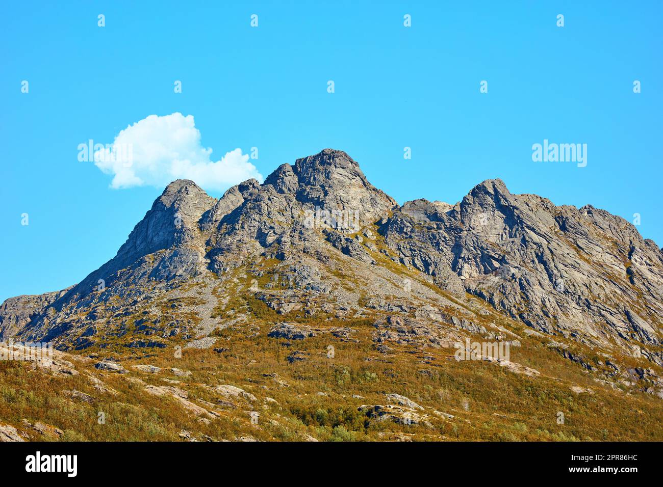 Landschaftsblick auf die Berge, blauer Himmel mit Wolken und Kopierraum in Norwegen. Wandern, Entdecken der malerischen Landschaft und des rauen Geländes. Die Sonne scheint auf einem weiten Naturschutzgebiet und Wanderweg Stockfoto