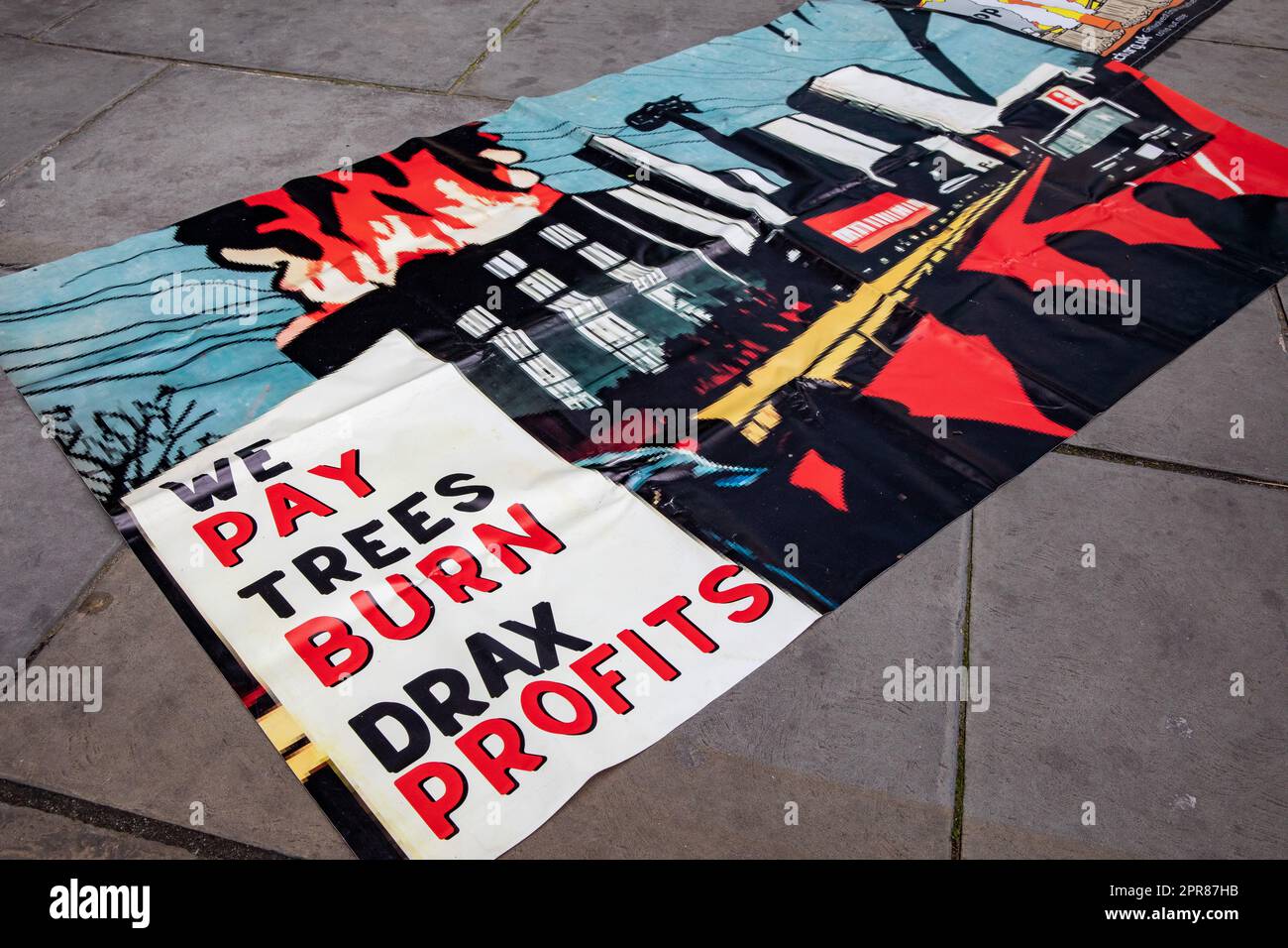 London, Großbritannien. 26. April 2023. Ein Banner, das von Umweltaktivisten zu einem Protest vor der jährlichen Hauptversammlung des größten Bioenergielieferanten des Vereinigten Königreichs Drax gebracht wurde, ist abgebildet. Die britische Energieregulierungsbehörde Ofgem untersucht derzeit die Einhaltung der Nachhaltigkeitsregeln durch Drax unter zunehmender Prüfung der Aktivitäten des Unternehmens, einschließlich der Holzquelle und der Beschreibung des zur Stromerzeugung verwendeten Verfahrens als „CO2-neutral“. Die staatlichen Subventionen für Drax für Biomasse werden derzeit voraussichtlich 2027 auslaufen. Drax hat heute seinen bisher höchsten Jahresertrag mit 731m Mio. GBP gegenüber 398m Mio. t bekannt gegeben Stockfoto