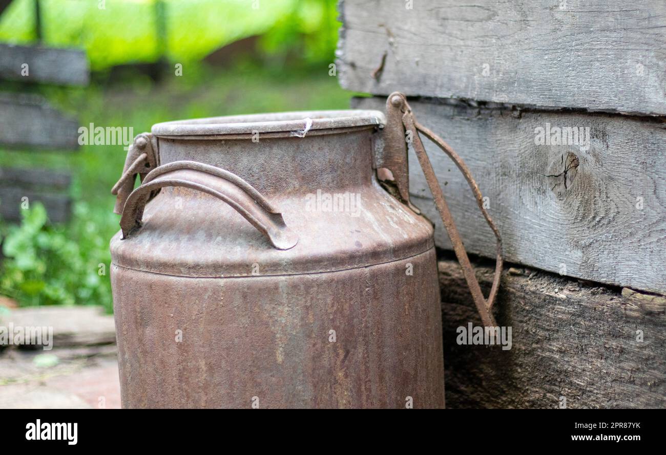 Eine alte rostige Metalldose auf dem Land. Behälter für den Transport von Flüssigkeiten, Milch oder flüssigen Kraftstoffen mit mehreren Griffen. Milchbank eines Zylinders Stockfoto Eine alte rostige Metalldose auf dem Land. Behälter für den Transport von Flüssigkeiten, Milch oder flüssigen Kraftstoffen mit mehreren Griffen. Milchbank eines Zylinders Stockfoto