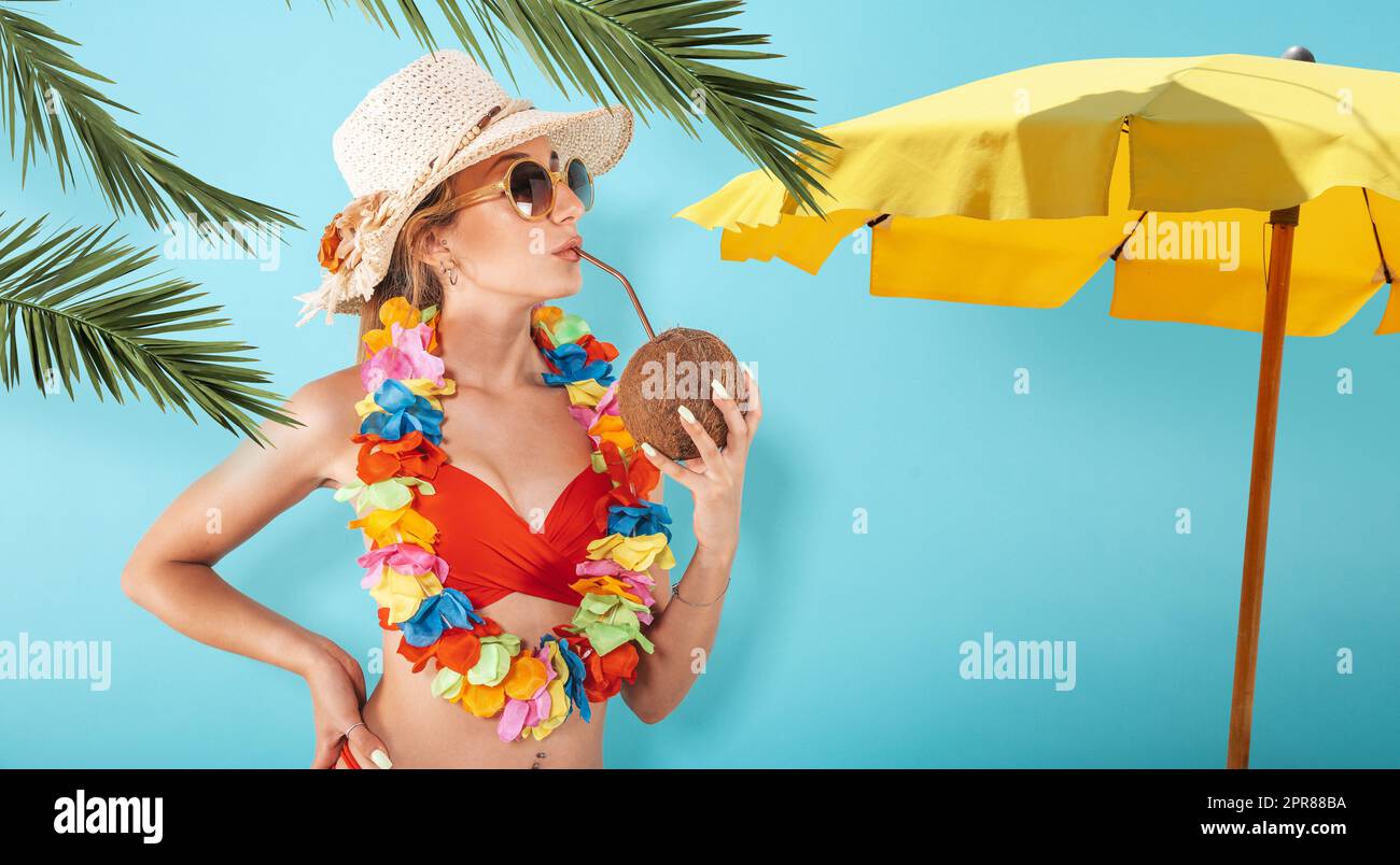 Frau mit Badeanzug erfrischend mit einer Kokosnuss Stockfoto