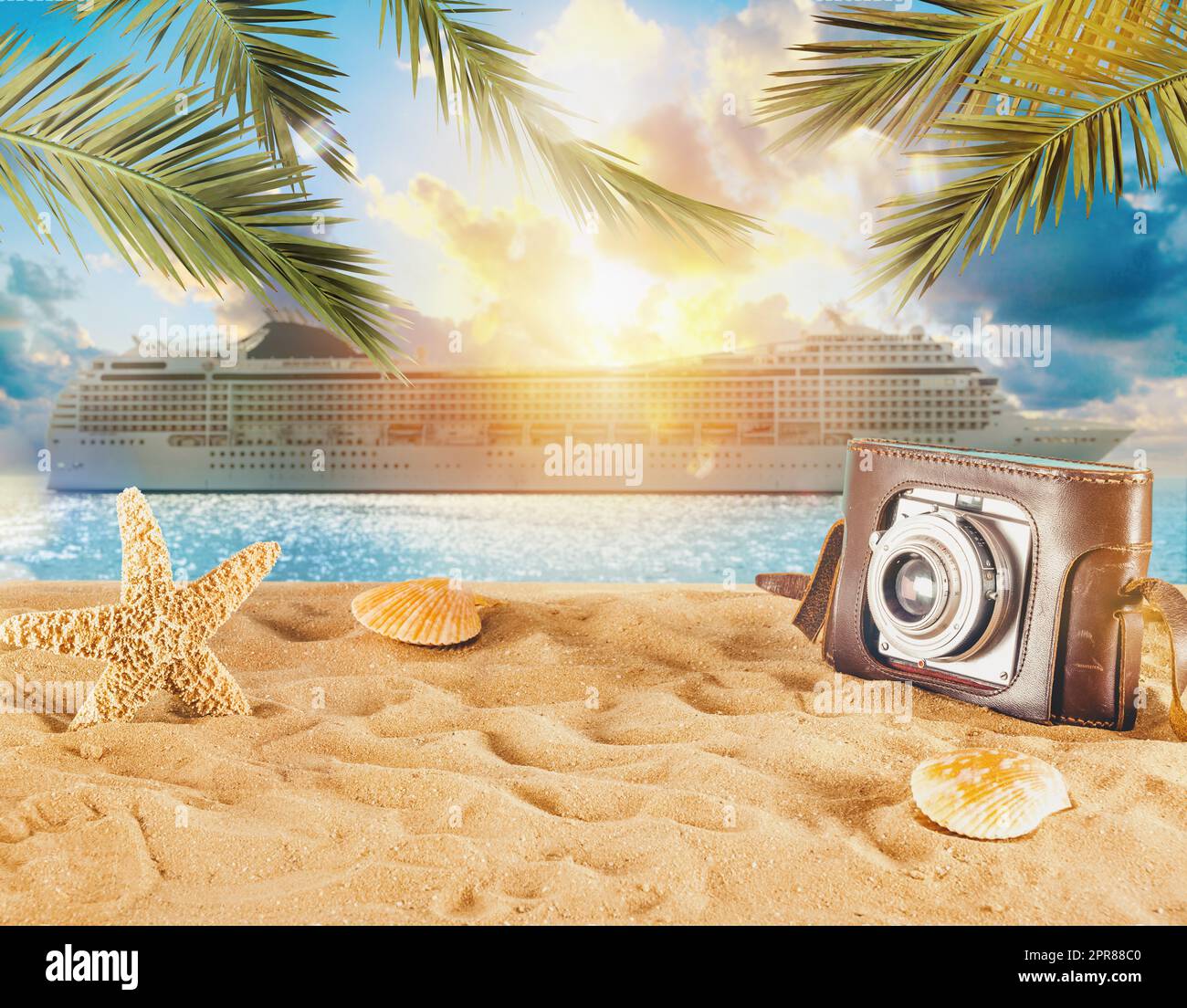 Strand mit Muscheln, Seesternen, Retro-Kamera und einem Kreuzschiff Stockfoto