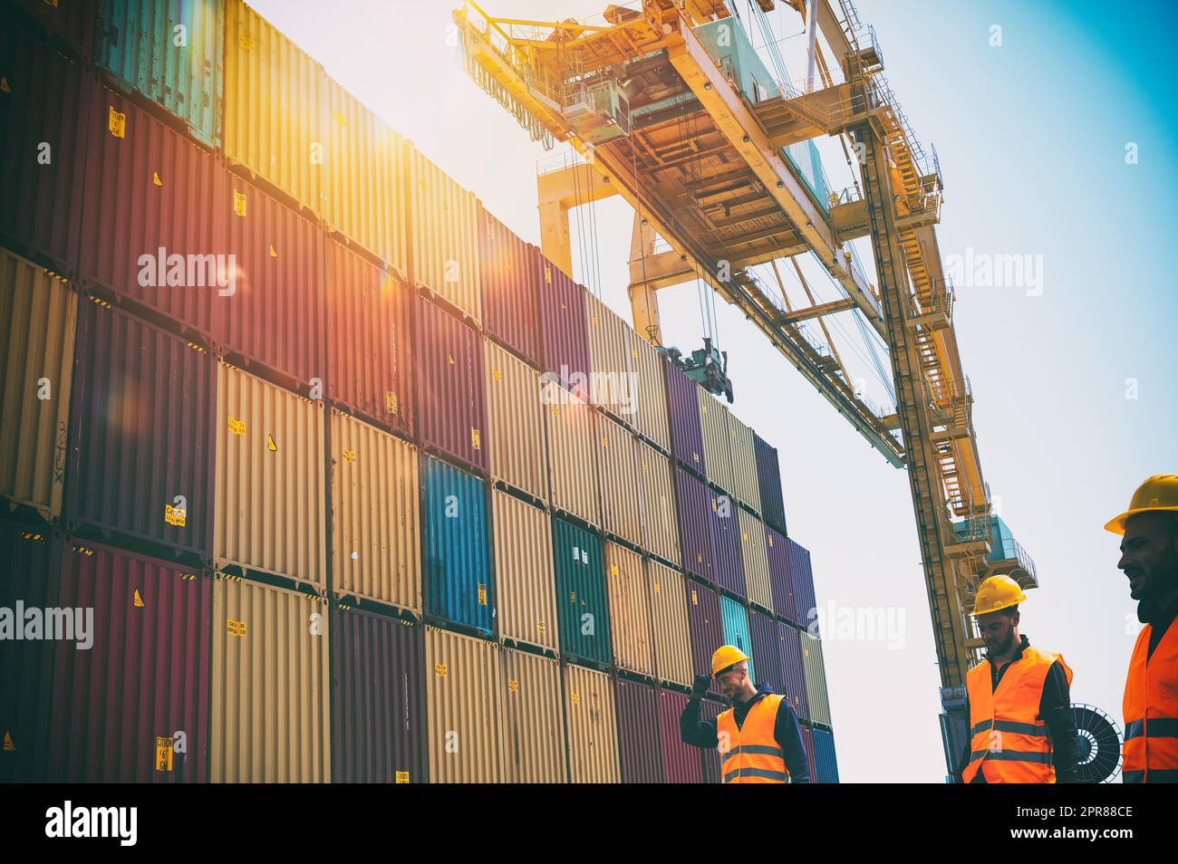 Männer bei der Arbeit zwischen Containern in einem Handelshafen Stockfoto