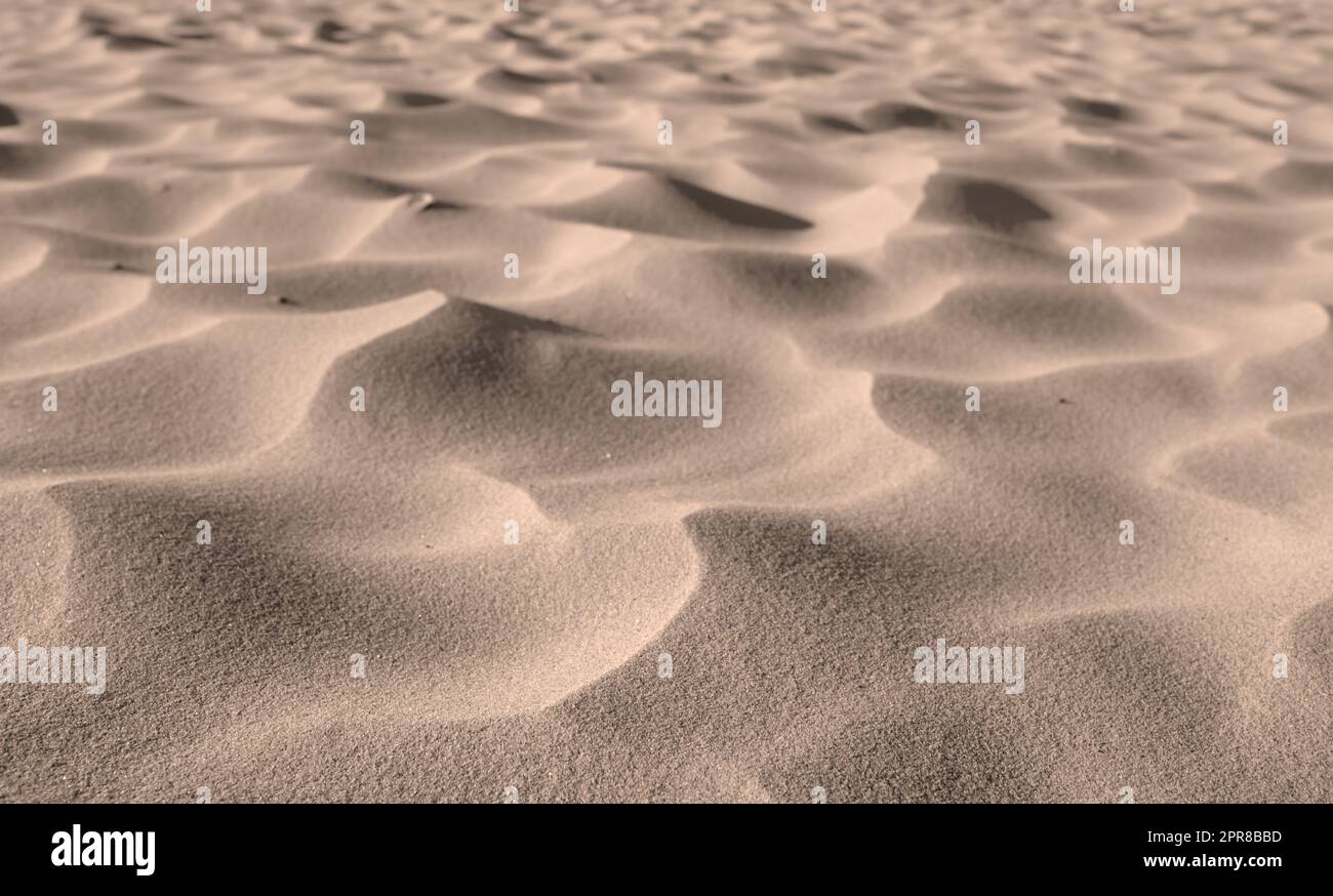 Wüstensandkörner aus Dünen an windigen Stränden in der Natur mit viel Platz. Nahaufnahme der Landschaft im Freien mit rauer und gewellter Oberflächenstruktur. Küstenregion für Reisen und Tourismus Stockfoto
