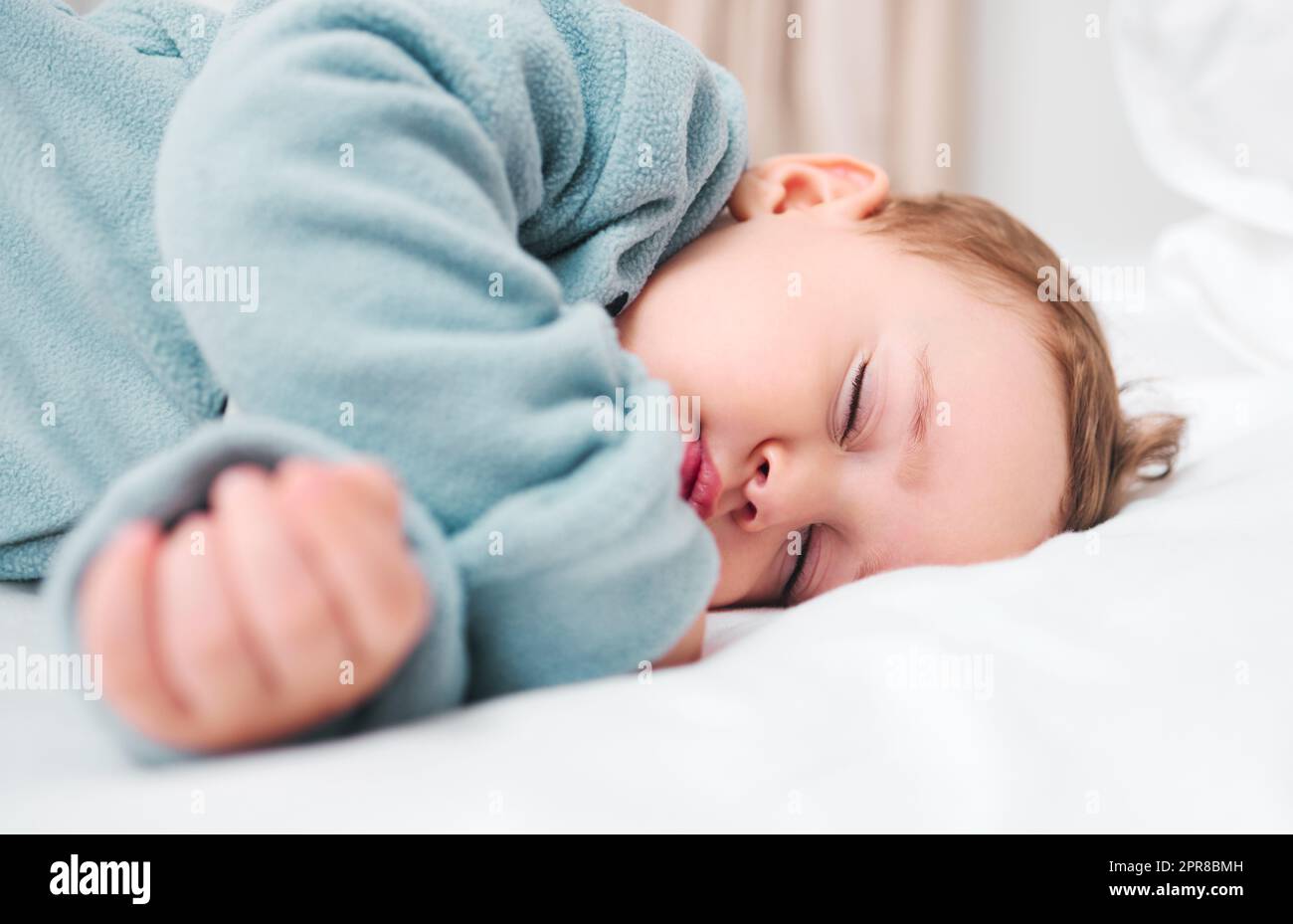 Ein entzückender Junge schläft auf einem Bett. Stockfoto