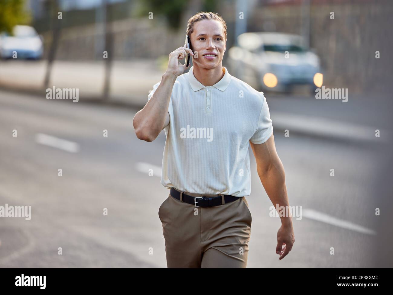 Ich bin fast da. Ein hübscher junger Geschäftsmann, der einen Anruf macht, während er durch die Stadt läuft. Stockfoto