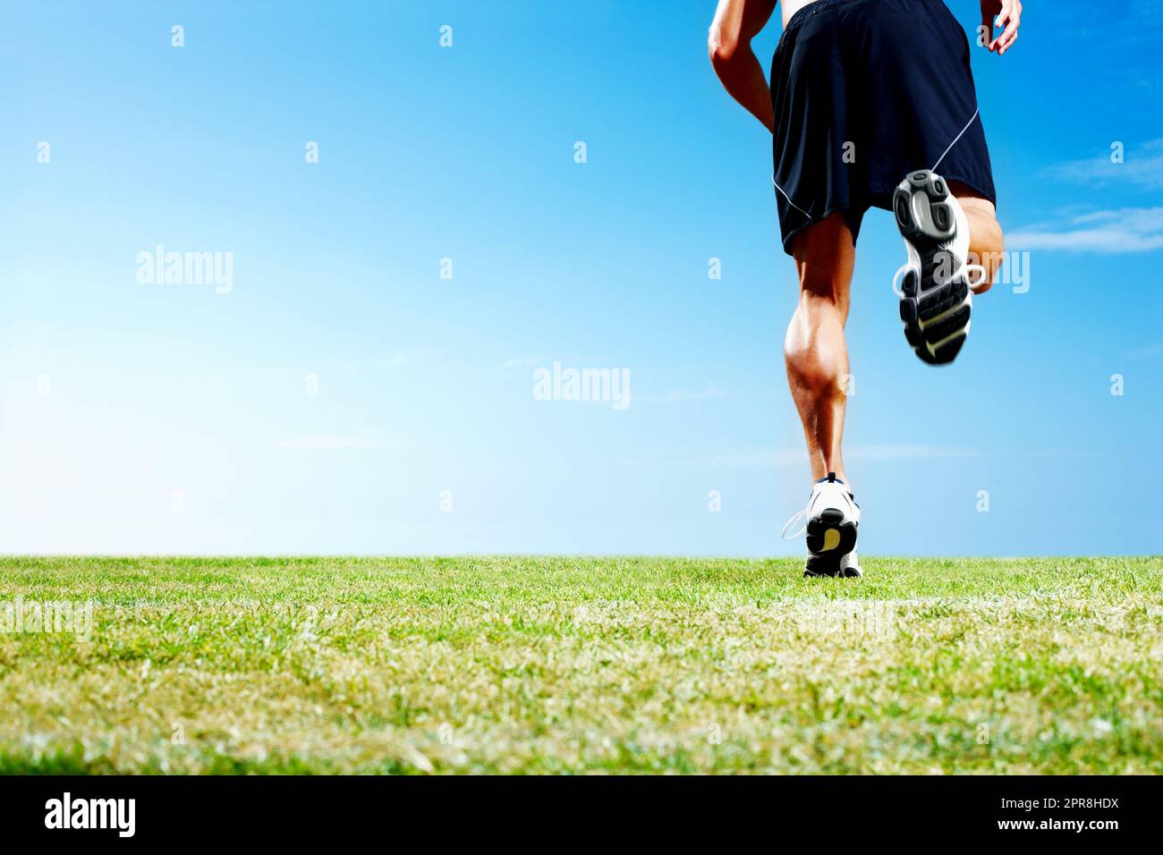 Junger Mann beim Joggen gegen den Himmel - Outdoor. Zugeschnittenes Bild eines jungen Mannes, der gegen den Himmel joggt - Copyspace. Stockfoto