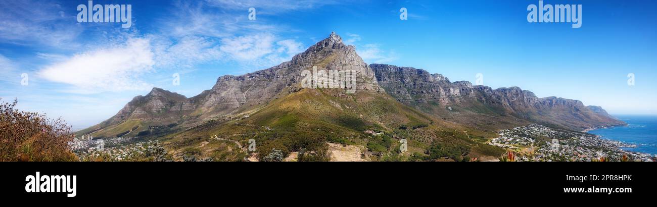 Panoramablick auf Berge, Meer und Küstenstadt mit blauem Himmel in berühmtem Reise- und Tourismusziel. Kopierraum und malerischer Blick auf die Natur des Tafelbergreservats in Kapstadt, Südafrika Stockfoto