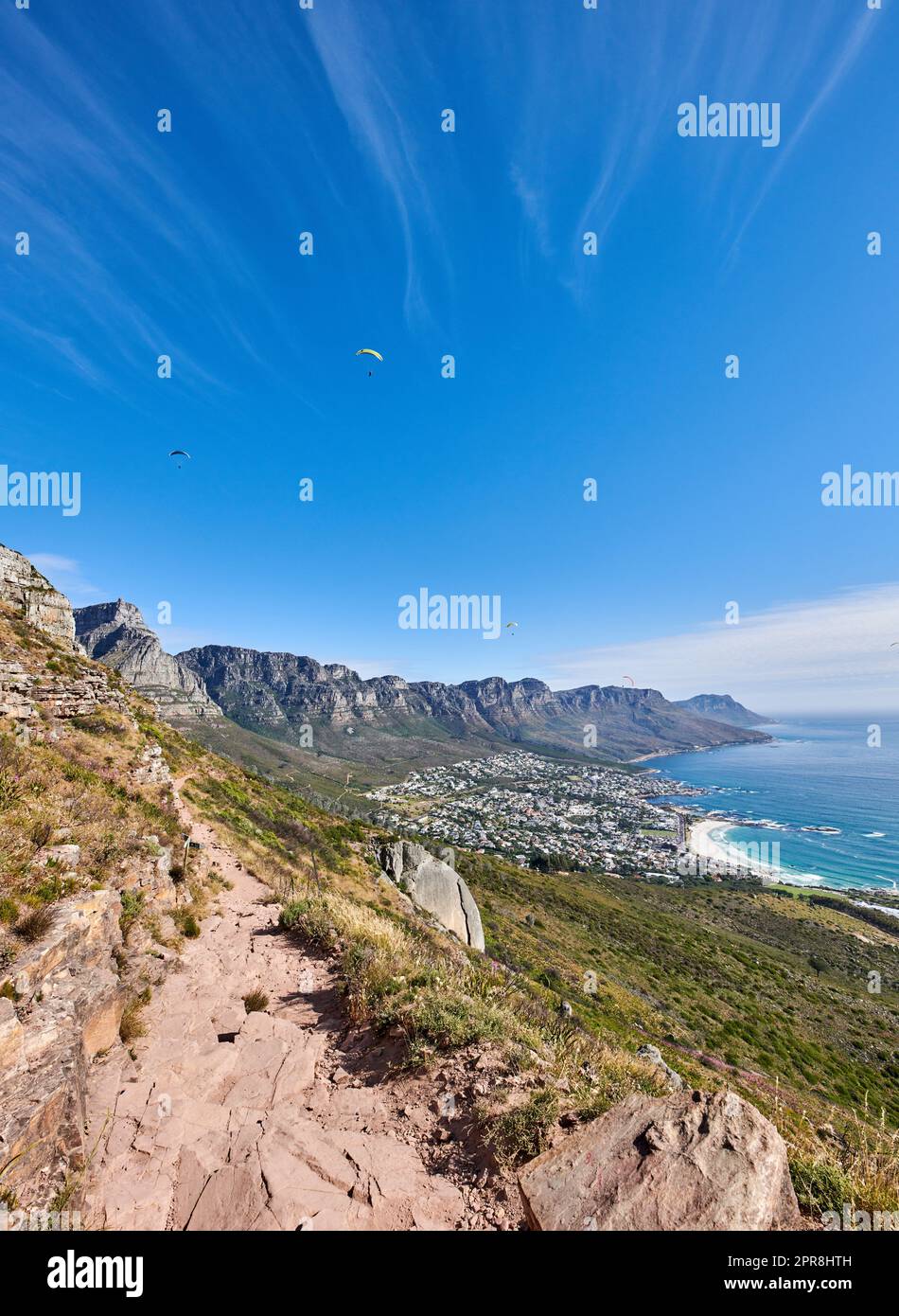 Berühmter Bergwanderweg mit Kopierraum, rauen Felsen oder Steinen, der zu einem malerischen Blick auf die zwölf Apostel in Kapstadt führt. Landschaft mit Meer, Meer und Küstenstadt mit blauem Himmel aus dem Naturschutzgebiet Stockfoto