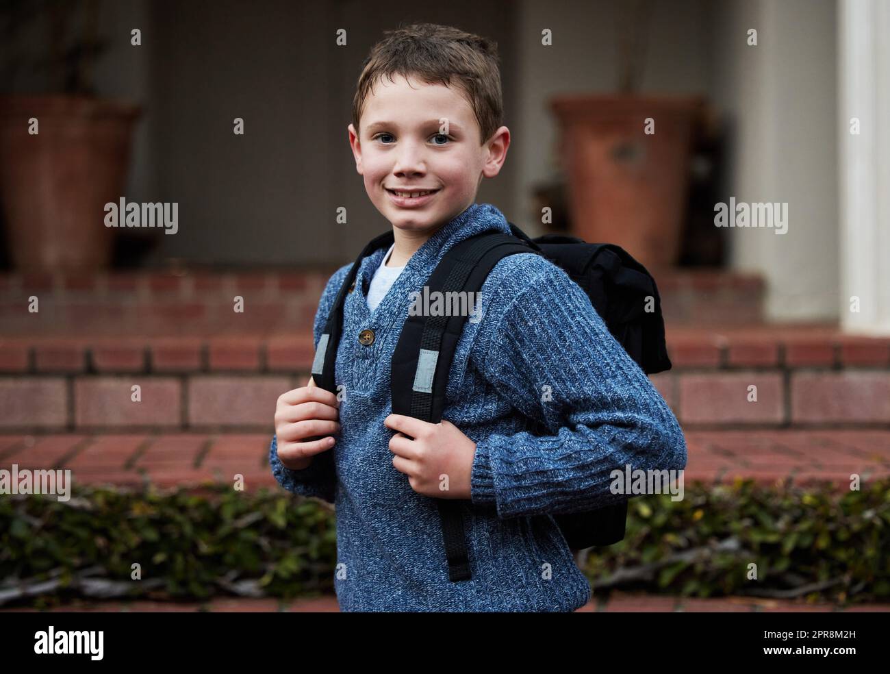 Bereit, neue Freunde zu finden. Ein kleiner Junge, der sich bereit macht, zur Schule zu gehen. Stockfoto