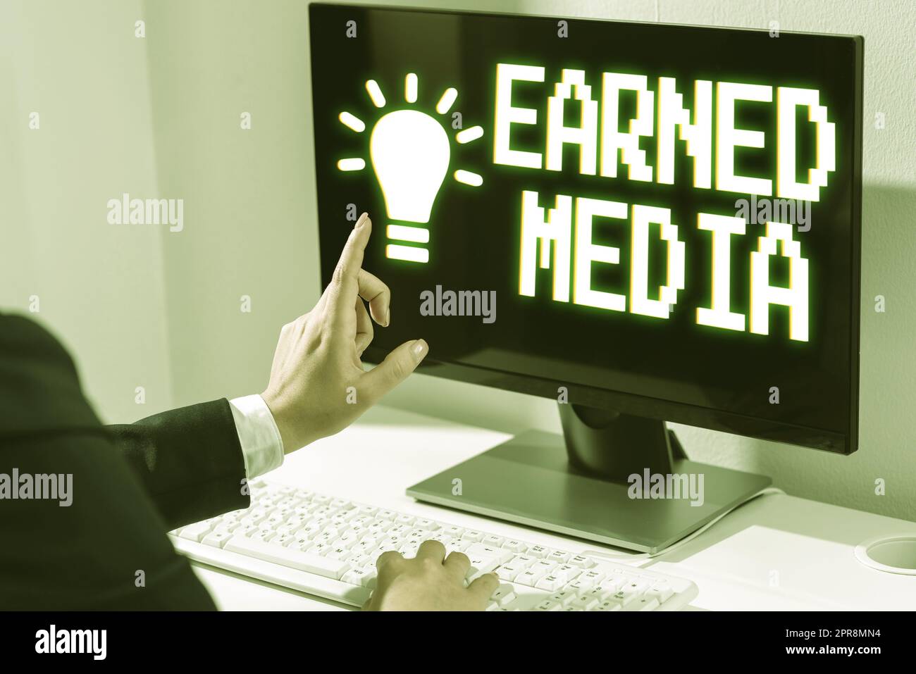 Schreiben mit Text Earned Media. Word for Publicity wurde durch Werbemaßnahmen von Multimedia-Frauen gewonnen, die Updates auf Lap Top eingeben und mit einem Finger auf neue Ideen zeigen. Stockfoto