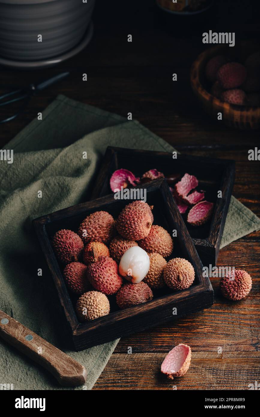 Litchi-Früchte in Holzbehälter Stockfoto