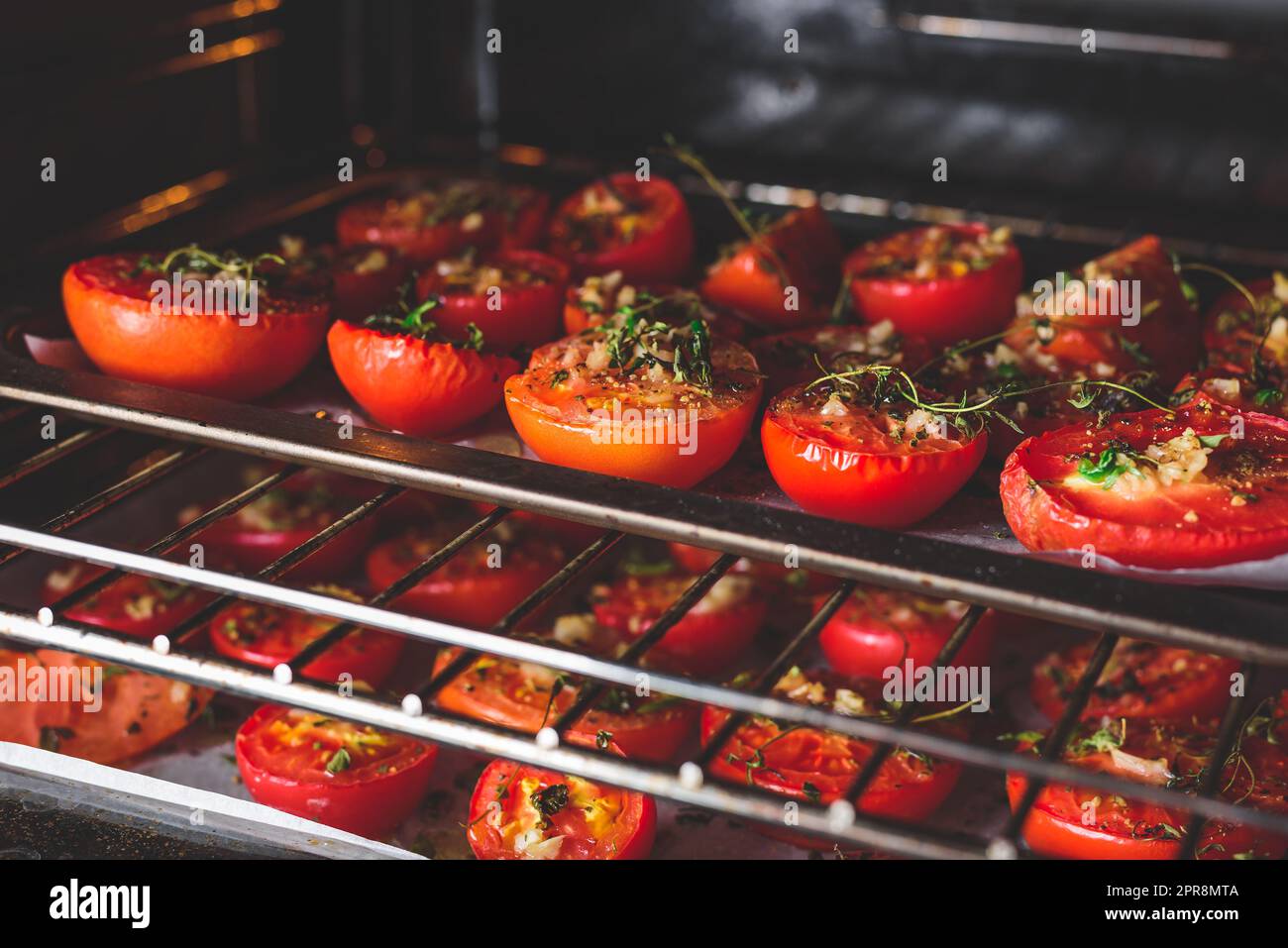 Tomaten mit Kräutern und Knoblauch im Ofen backen Stockfoto
