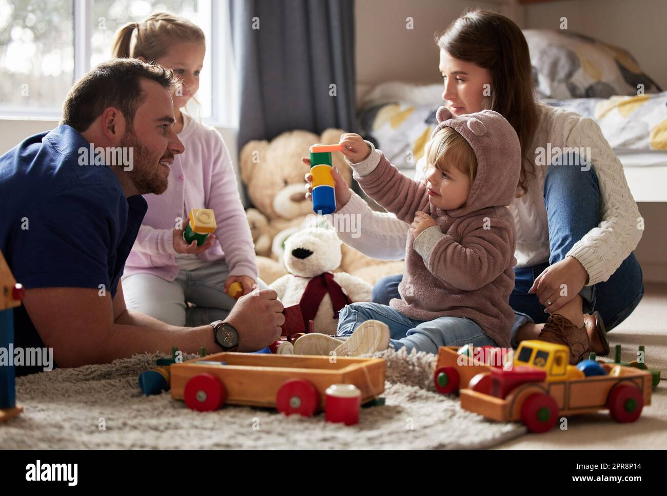 Es gibt nichts Wertvolleres als die Zeit der Familie. Eine junge Familie spielt zu Hause zusammen. Stockfoto