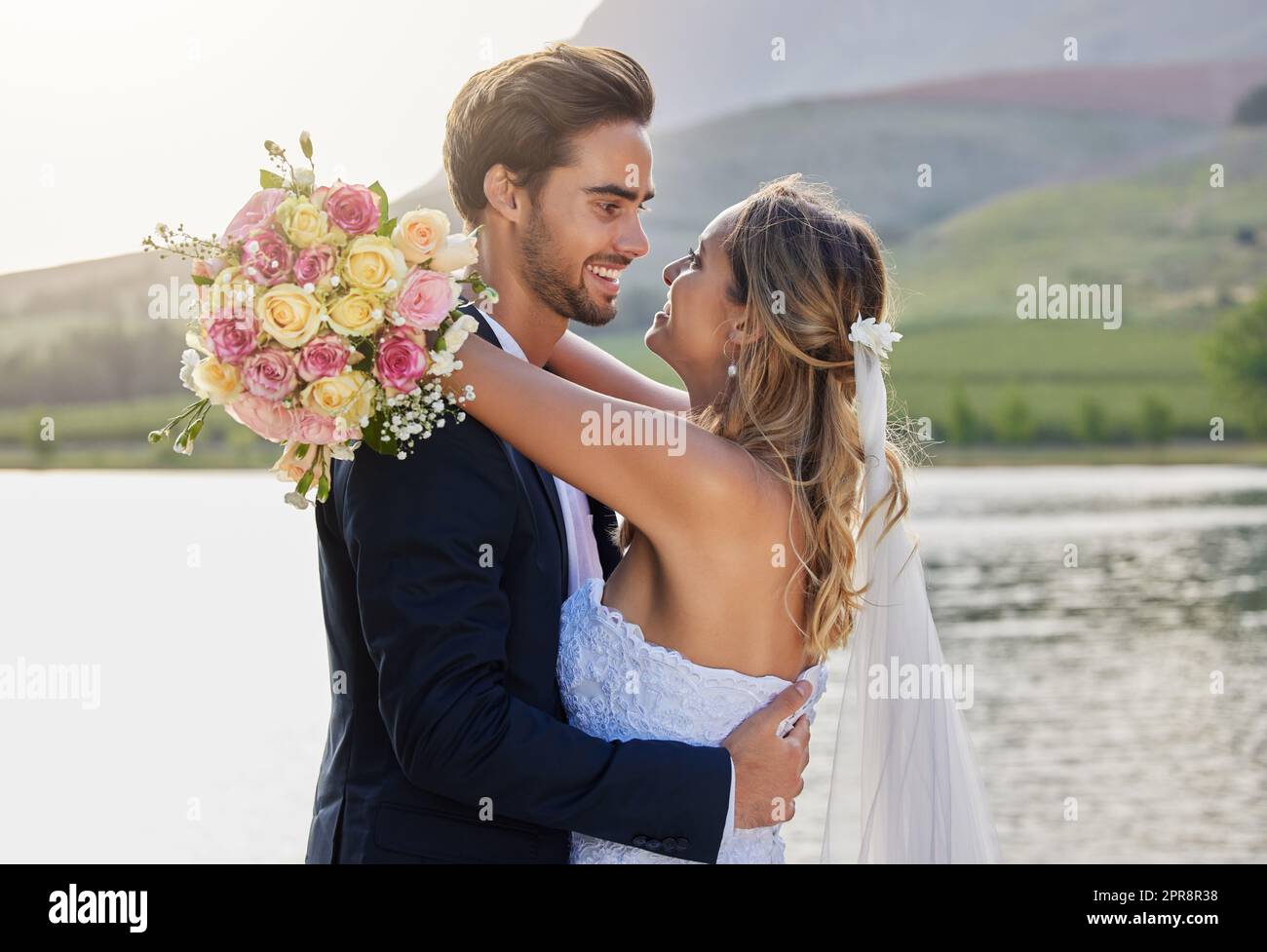 Feiern von Liebe und Glück. Eine liebevolle Braut und ein Bräutigam draußen an ihrem Hochzeitstag. Stockfoto