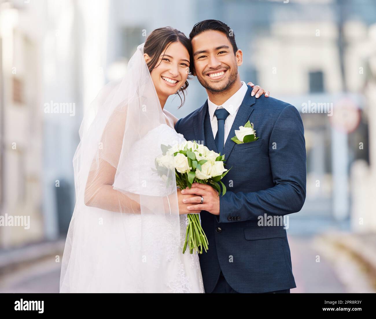 Wo Liebe ist, ist Leben. Ein schönes Paar draußen in der Stadt an ihrem Hochzeitstag. Stockfoto