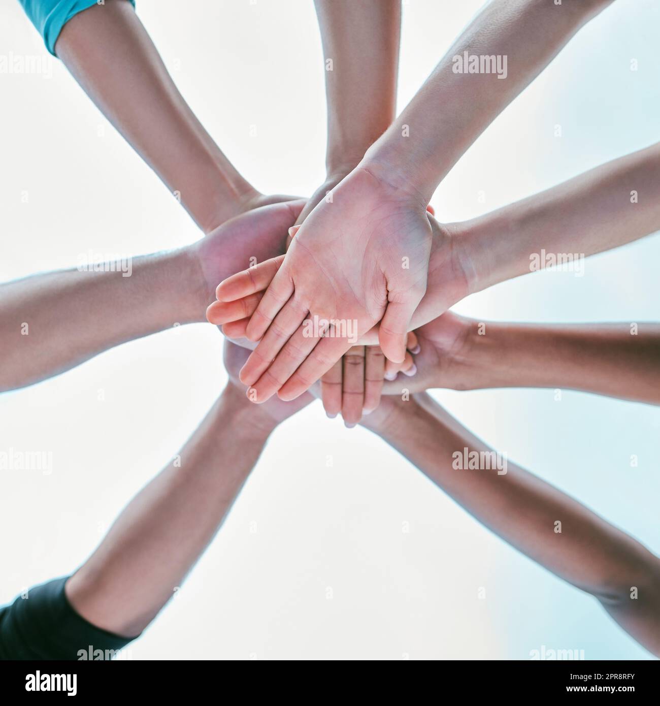 Nahaufnahme einer vielfältigen Gruppe von Personen aus der unteren Reihe, die ihre Hände auf einem Stapel stapeln, um Einheit, Unterstützung und Vertrauen auszudrücken. Multiethnische Gemeinschaft, die sich in einem Kreis zusammengeschlossen hat, um siegreiche Erfolge zu feiern. Teilnahme für Zusammenarbeit und Teamgeist Stockfoto