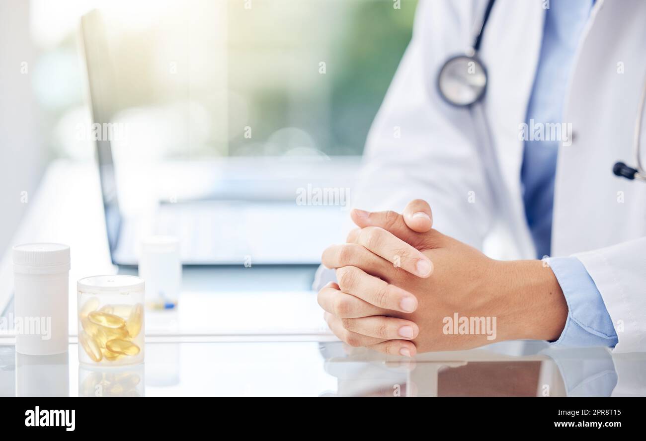 Der Spezialist im Gesundheitswesen. Nahaufnahme einer nicht erkennbaren Ärztin, die mit ihren Händen an einem Tisch in einem medizinischen Büro sitzt. Stockfoto