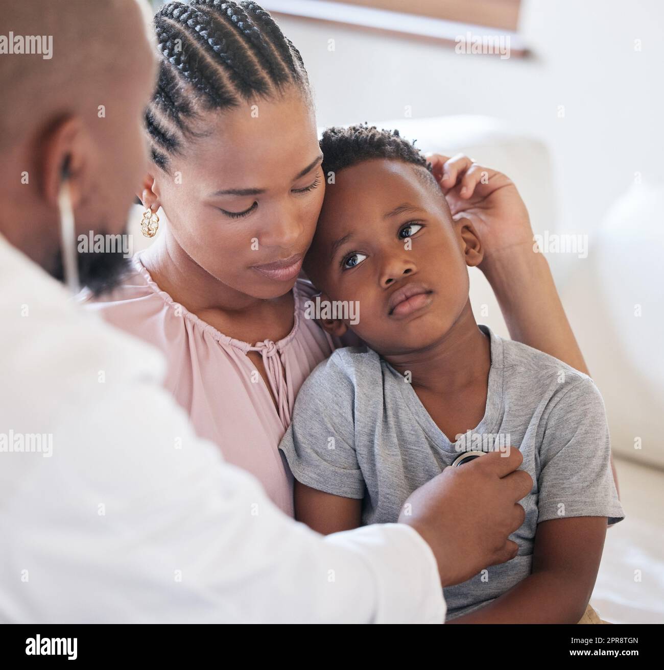 afroamerikanischer männlicher Kinderarzt, der einen kranken Jungen mit Stethoskop während des Besuchs mit mutter untersucht. Arzt prüft die Herzlunge bei der Untersuchung im Krankenhaus. Kranker oder trauriger Junge, der medizinisch versorgt wird Stockfoto