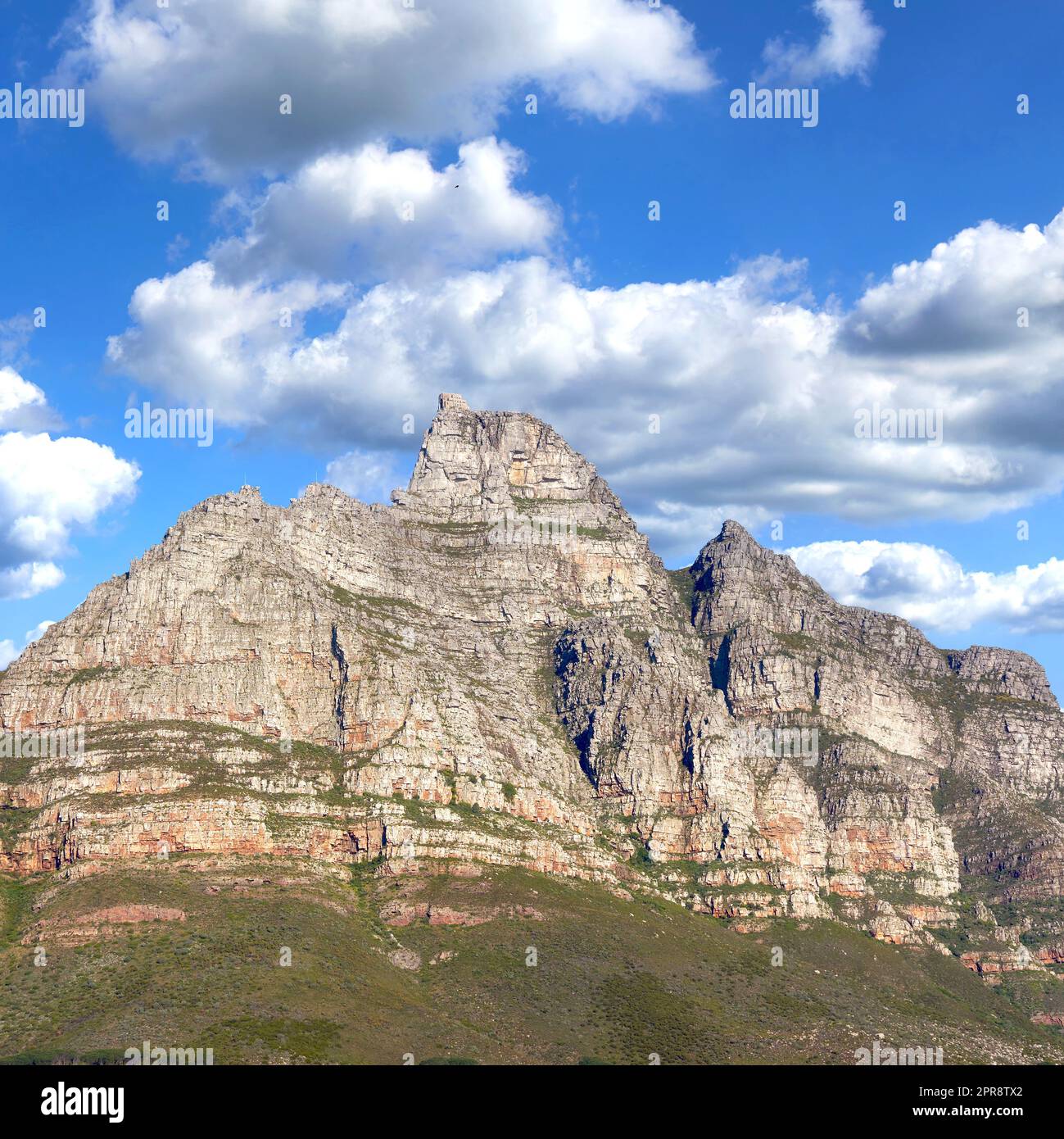 Felsige Berglandschaft mit grüner Weide vor blauem Himmel mit Copyspace. Ein beliebtes Reiseziel für Touristen und Wanderer. Blick auf den Tafelberg in Kapstadt, Westkap Stockfoto