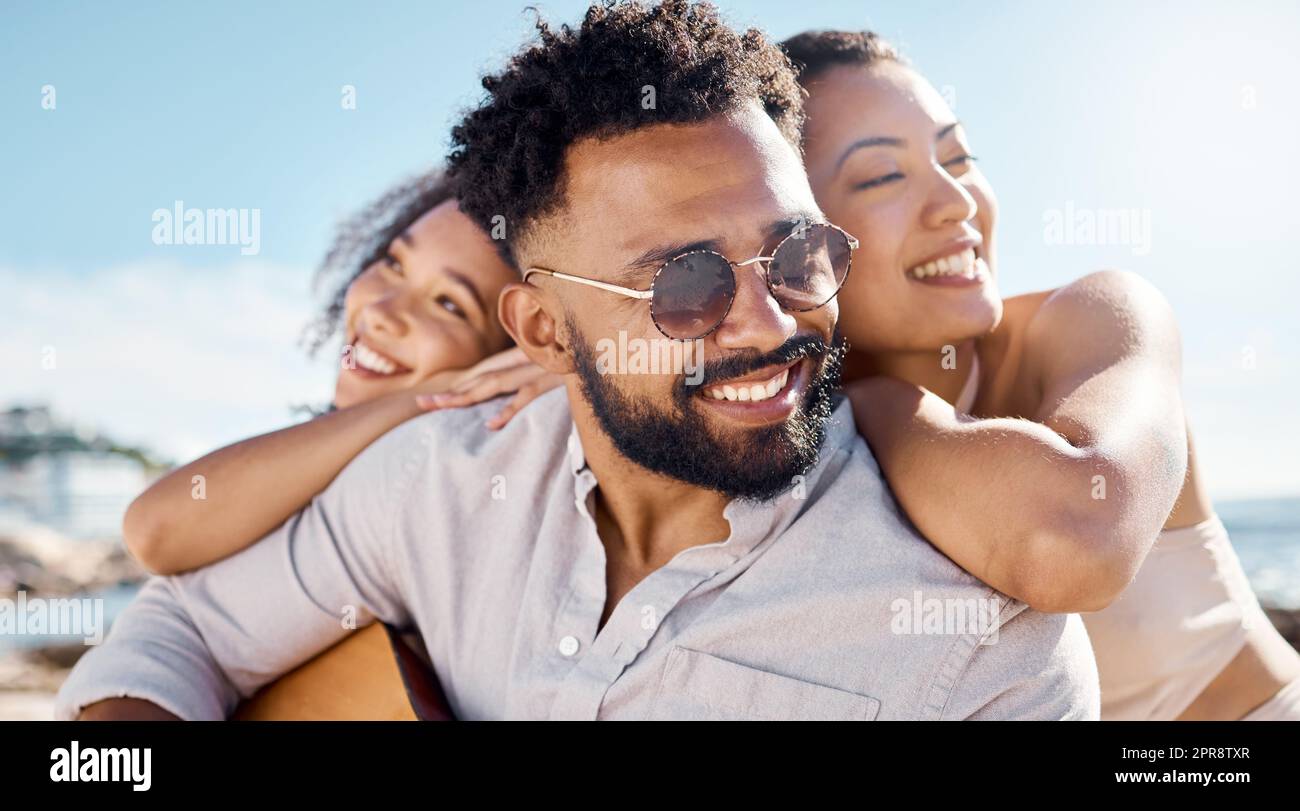 Der Strand hat eine Möglichkeit, Menschen näher zu bringen. Ein Mann am Strand mit seinen zwei Freundinnen. Stockfoto